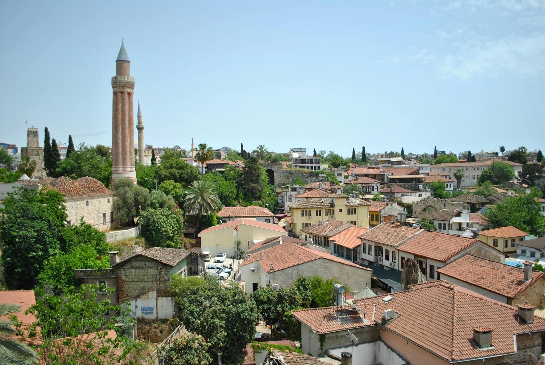 Vue panoramique de Kaleiçi avec ses maisons ottomanes, le célèbre Yivli Minaret historique et ses toits de tuiles oranges entourés de verdure dans la vieille ville d'Antalya.