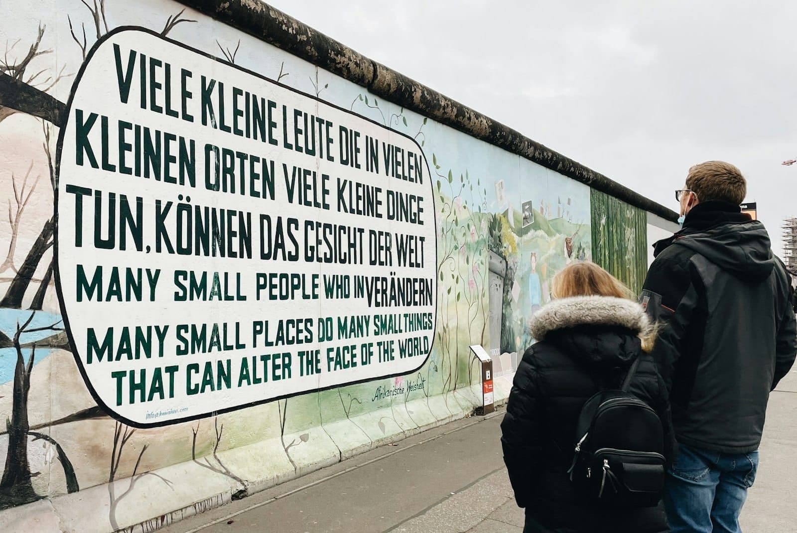 นักท่องเที่ยวชมภาพจิตรกรรมฝาผนังชื่อดังบนกำแพงเบอร์ลินที่ East Side Gallery ซึ่งมีข้อความสันติภาพหลายภาษา