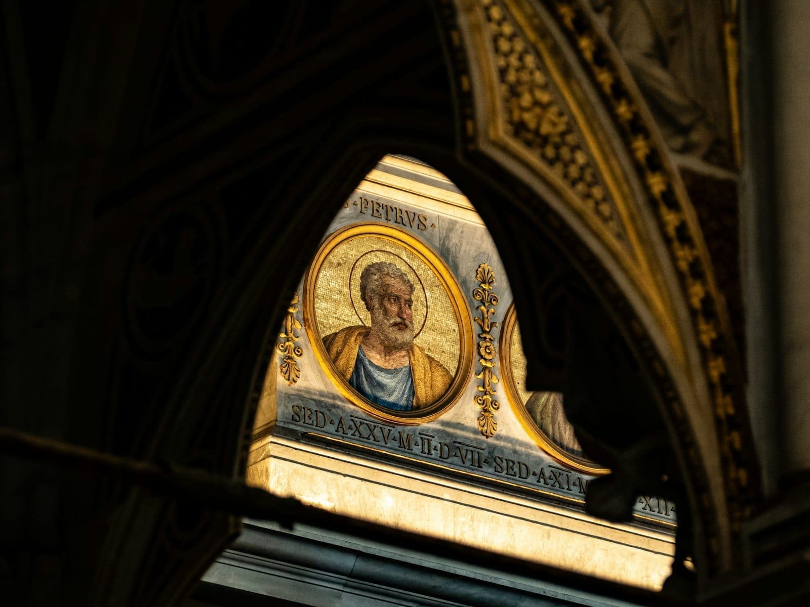 Retrato em mosaico de um santo ou apóstolo visto através de um arco gótico de igreja, iluminado no interior de uma igreja romana.