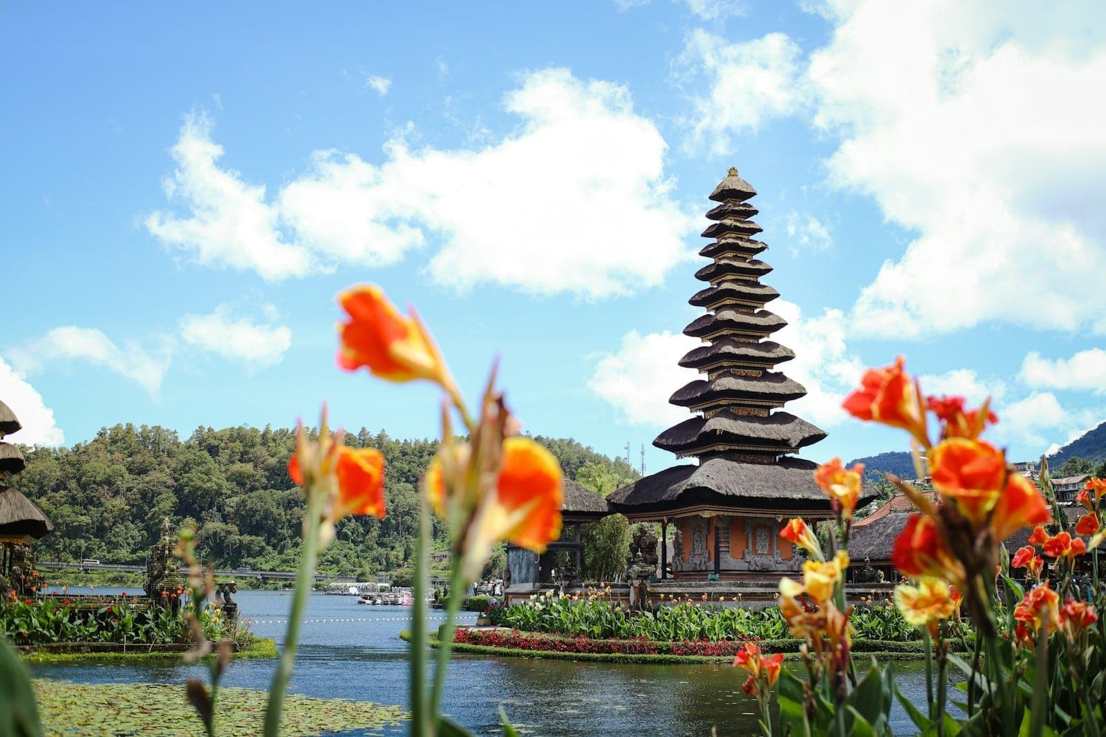 Ulun Danu Beratan Temple in Bali surrounded by flowers and lake scenery under blue skies