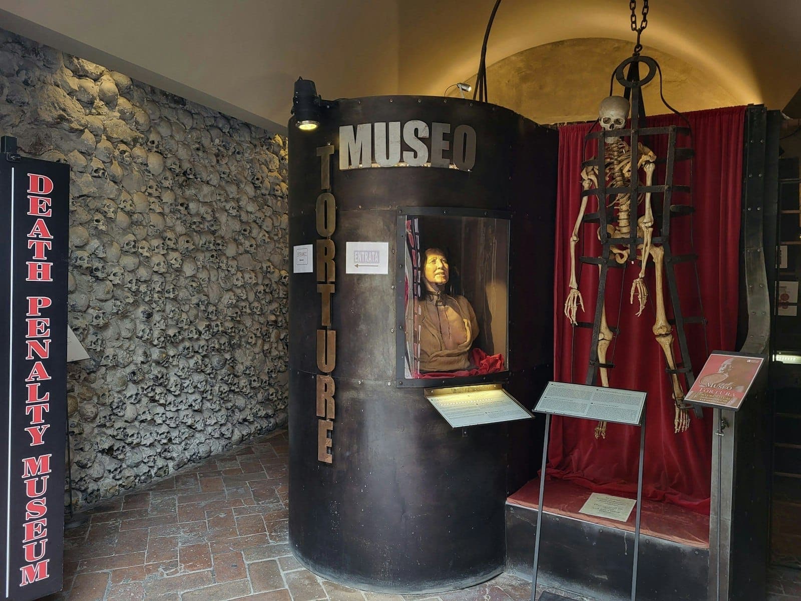 Entrada do Museu da Pena de Morte em Nápoles, com um esqueleto, figura de cera e exposição de instrumentos de tortura.