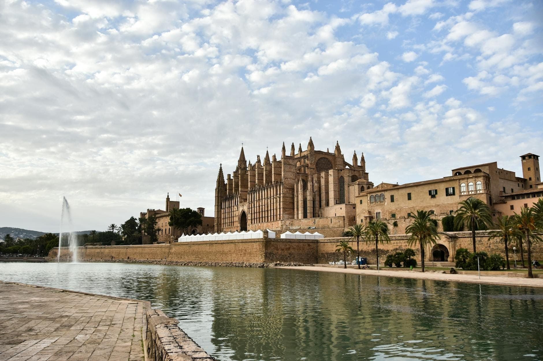 La cattedrale di Palma e il lungomare deserto sotto cieli nuvolosi, che trasmettono un'atmosfera tranquilla di bassa stagione a Maiorca.