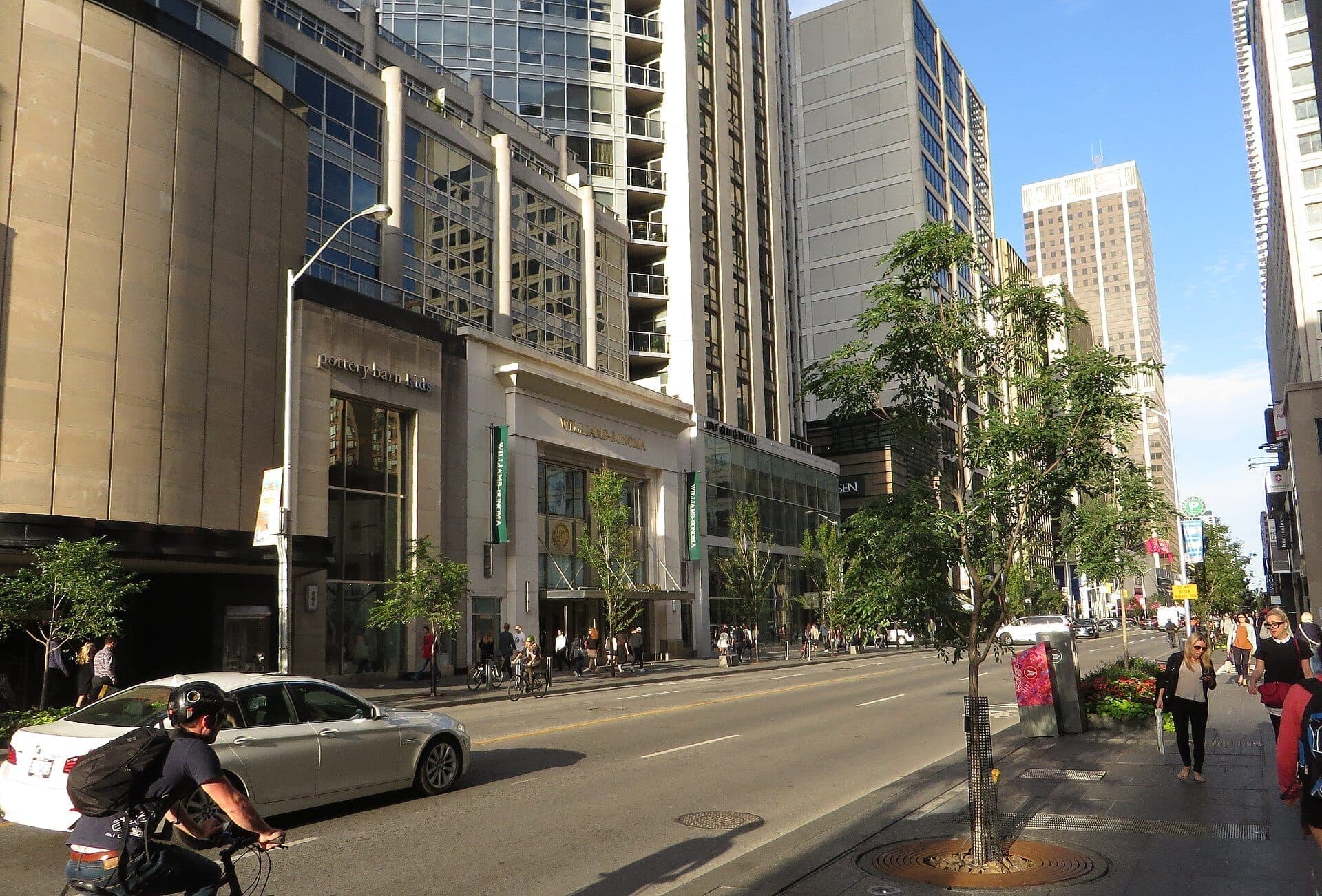 Edifici moderni, negozi di lusso e pedoni animano il soleggiato paesaggio urbano della Bloor-Yorkville Mink Mile a Toronto, nel cuore della città.