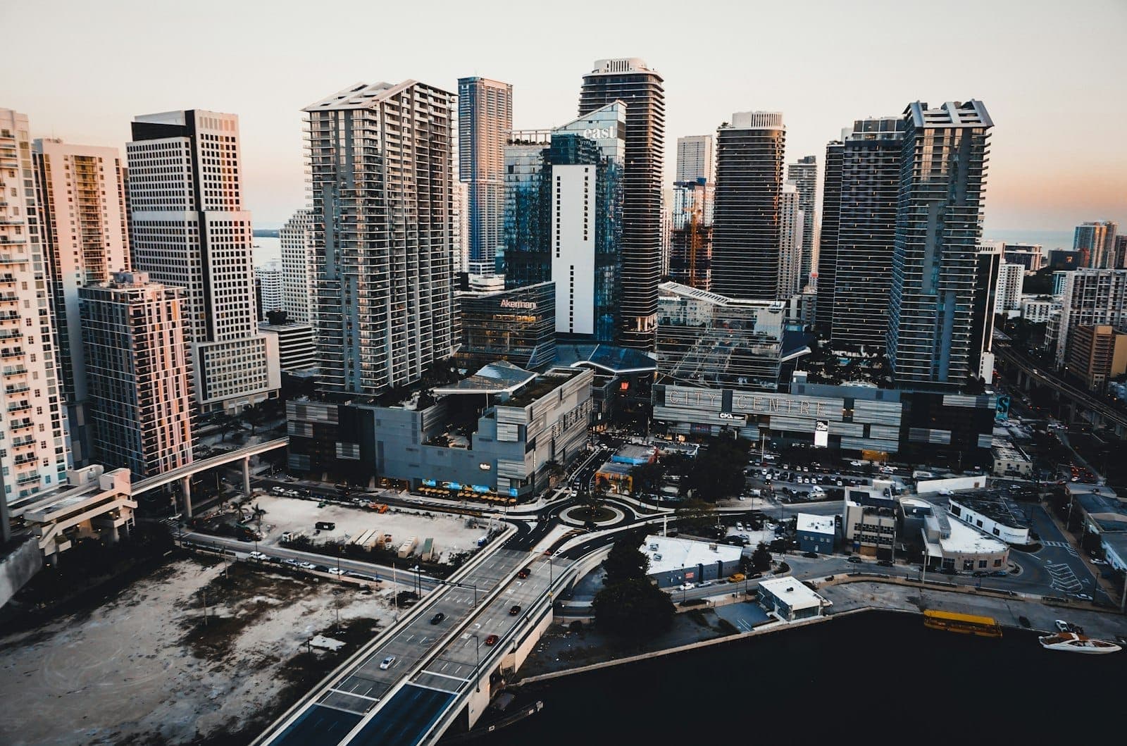 Vue aérienne du Brickell City Centre à Miami, mettant en valeur des gratte-ciel modernes, des bâtiments commerciaux et des rues de la ville au crépuscule.