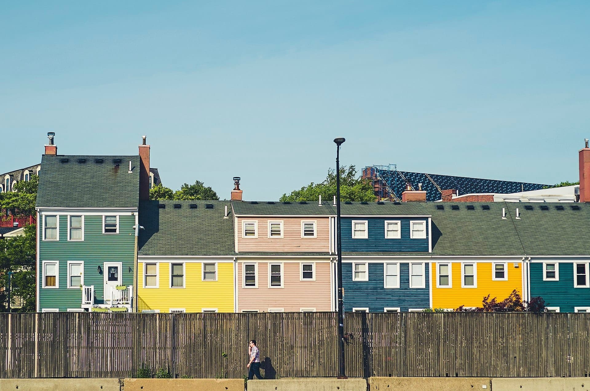 Rangée de maisons de ville historiques colorées à Charlestown, Boston, vues derrière une clôture en bois par une journée claire et ensoleillée.