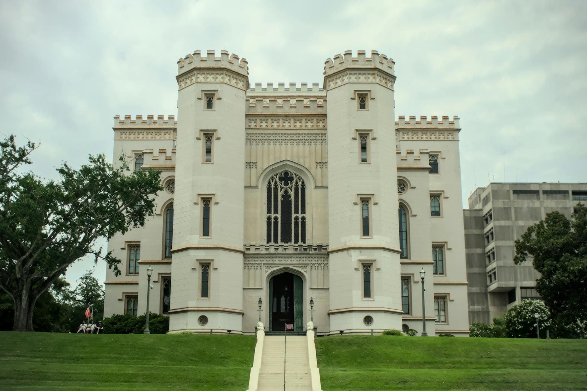 Vorderansicht des Old State Capitol Gebäudes in Baton Rouge mit gotischen Türmen und gepflegtem Rasen.