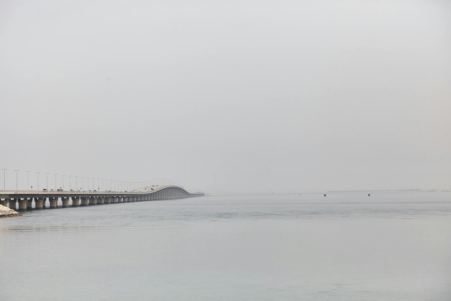 Lange Brücke über das Wasser, die sich über den Lake Pontchartrain erstreckt, mit ruhigem Wasser und diesigem Himmel
