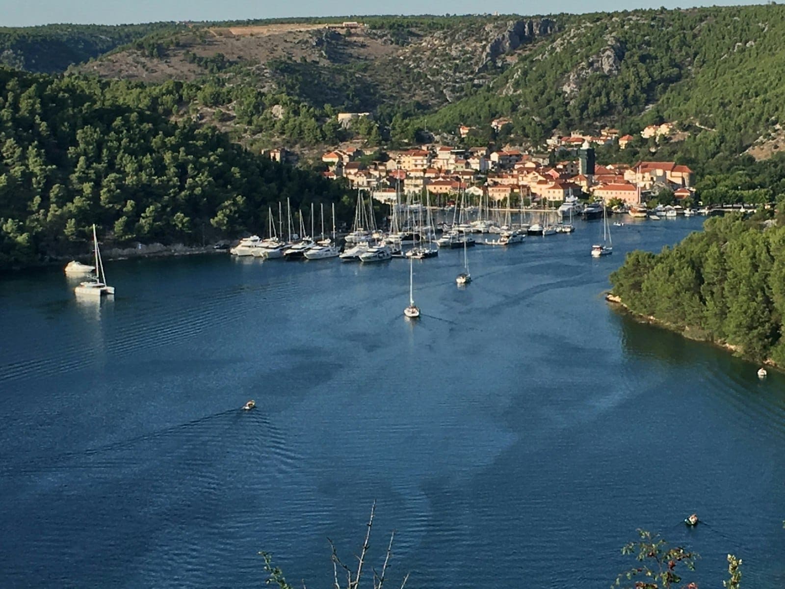 Vue de Skradin avec les bateaux de la marina, la rivière et les collines environnantes, montrant l'emplacement de la ville au bord de la rivière près du Parc National de Krka.