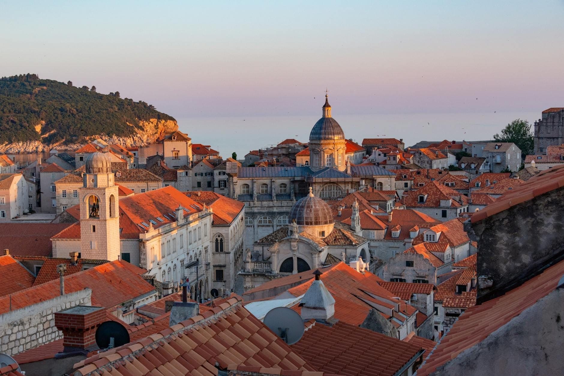 Blick über die Dächer der Altstadt von Dubrovnik bei Sonnenuntergang mit der Kirche des Heiligen Blasius und den umliegenden historischen Gebäuden.