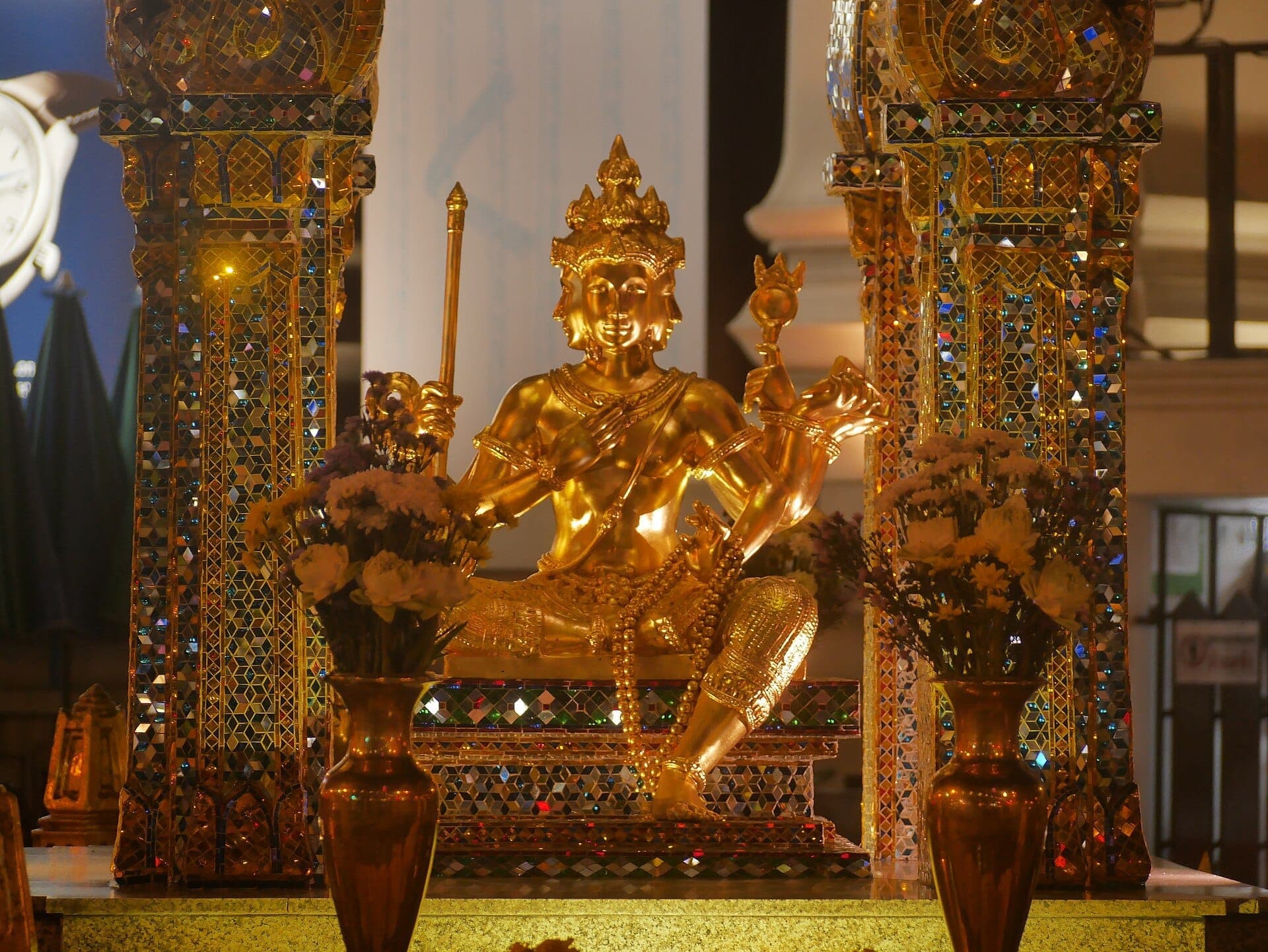 Świątynia Erawan w Bangkoku ze złotym posągiem Brahmy i ozdobnymi filarami sanktuarium