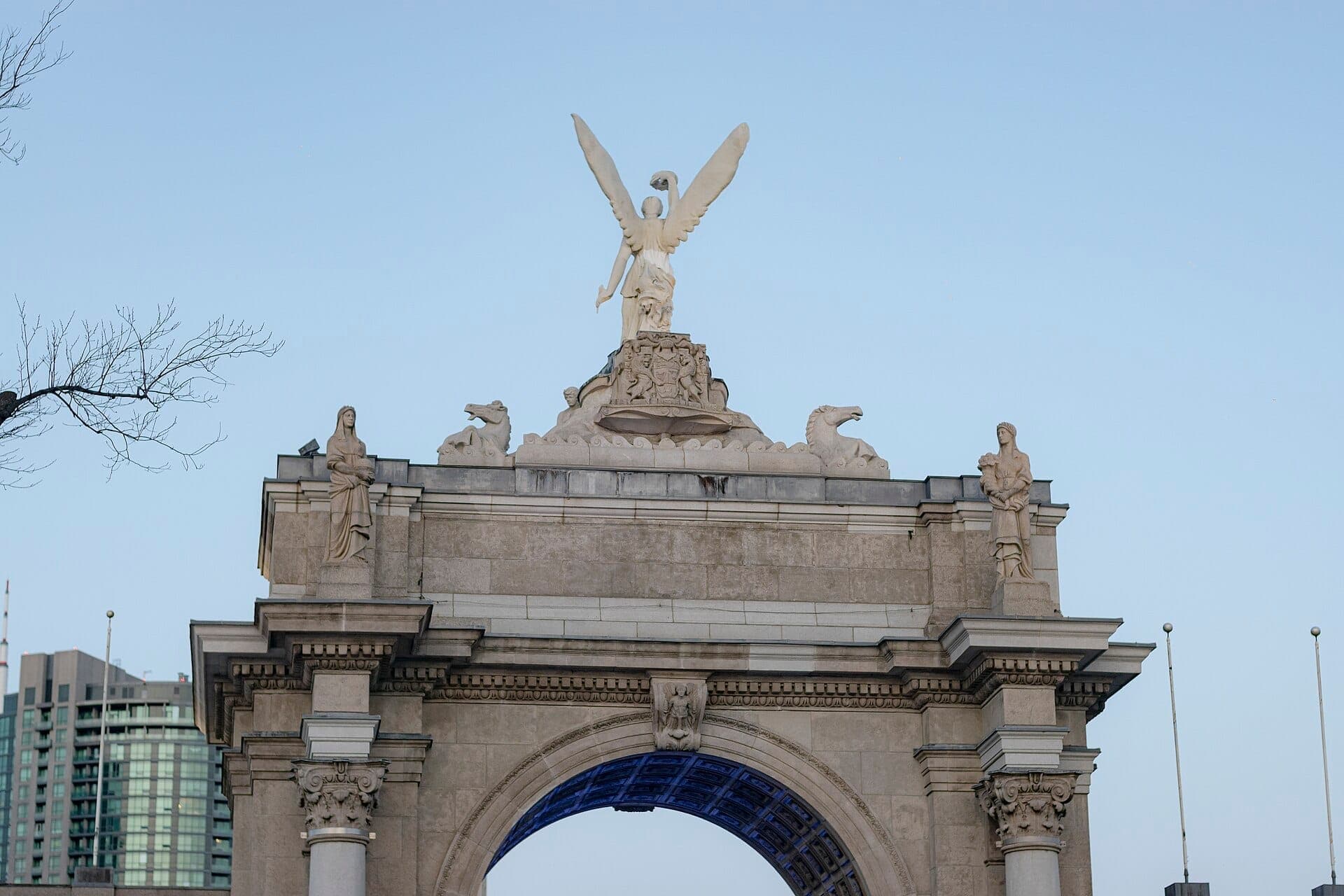 I Princes' Gates all'Exhibition Place di Toronto, con statue classiche, una scultura di un angelo e il cielo nel tardo pomeriggio sullo sfondo.