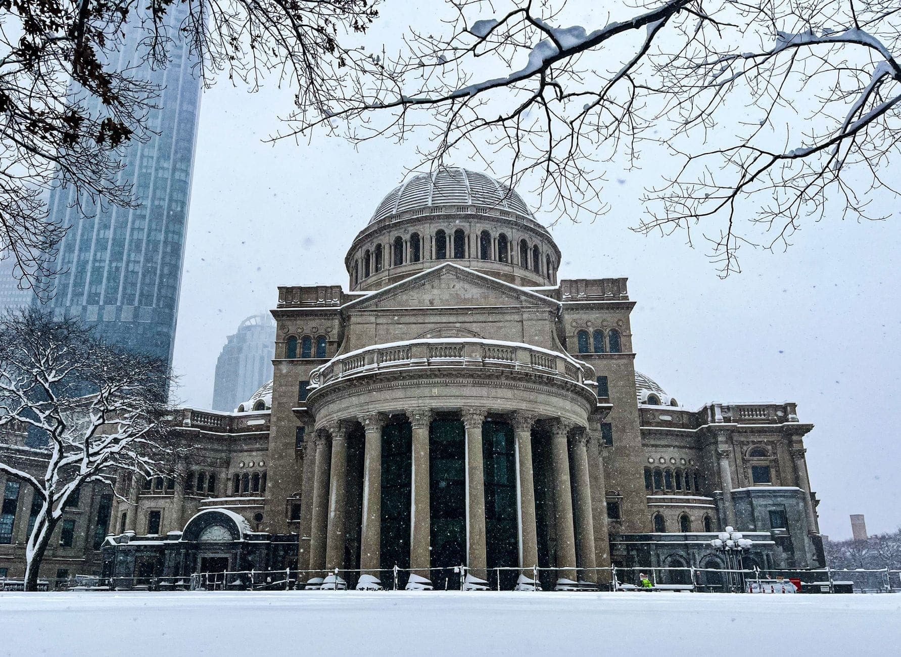 Vue hivernale saisissante de la First Church of Christ, Scientist à Boston, avec la neige au sol et la coupole néoclassique ainsi que les colonnes clairement visibles.