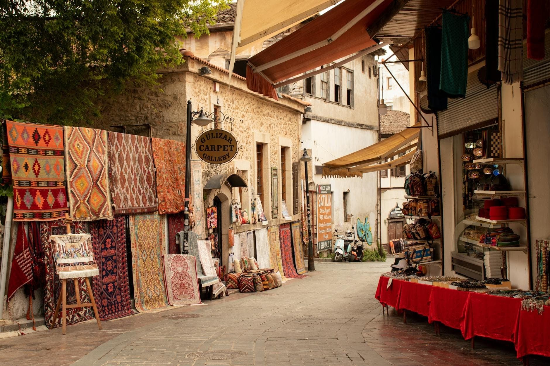 Malerische Straße im alten Basar von Antalya mit Teppichen, Souvenirs und historischen Steingebäuden entlang des Weges.