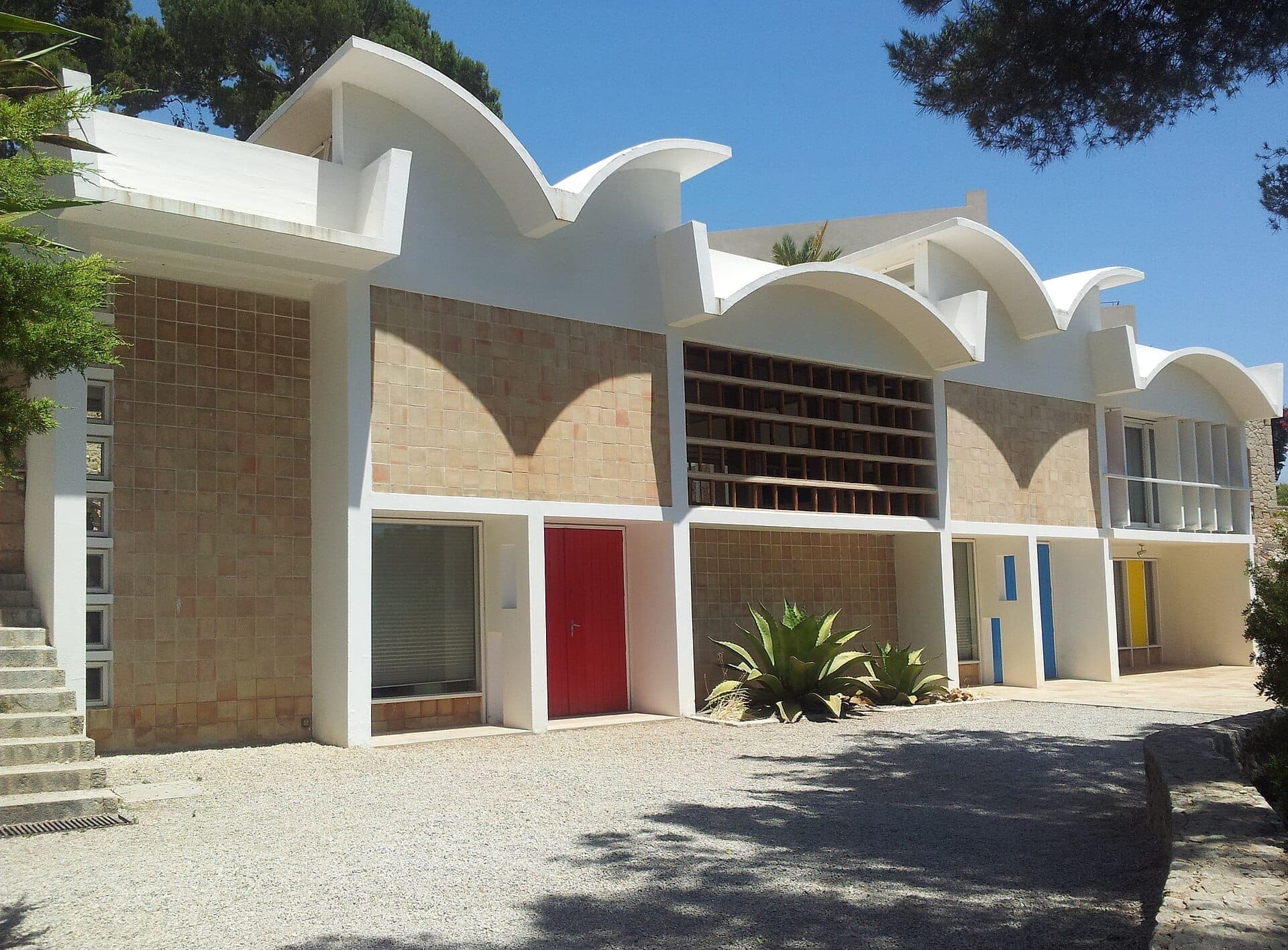 Außenansicht der Fundació Pilar i Joan Miró in Palma mit modernistischer Architektur, geschwungenen weißen Dachlinien und geometrischen Akzenten in Rot, Blau und Gelb.