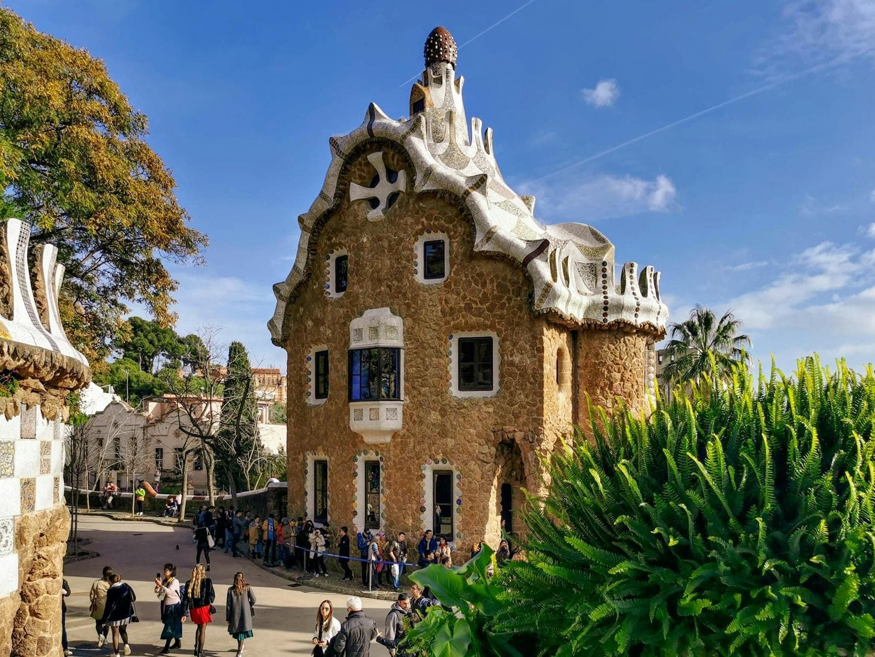 Eksterior Museum Rumah Gaudí di Park Güell dengan pengunjung dan arsitektur khas yang unik pada hari yang cerah.