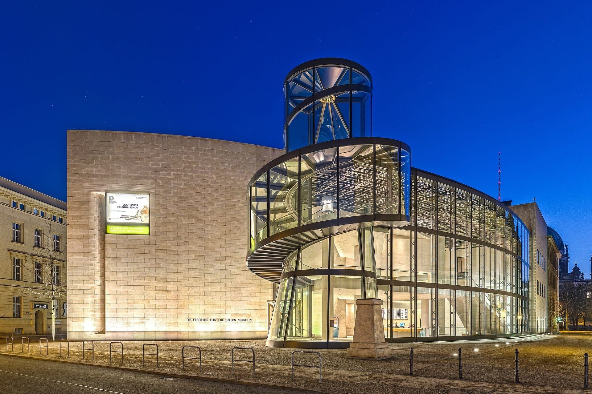 Современная стеклянная и каменная архитектура пристройки I.M. Pei Немецкого исторического музея (Deutsches Historisches Museum), освещённой ночью в Берлине.