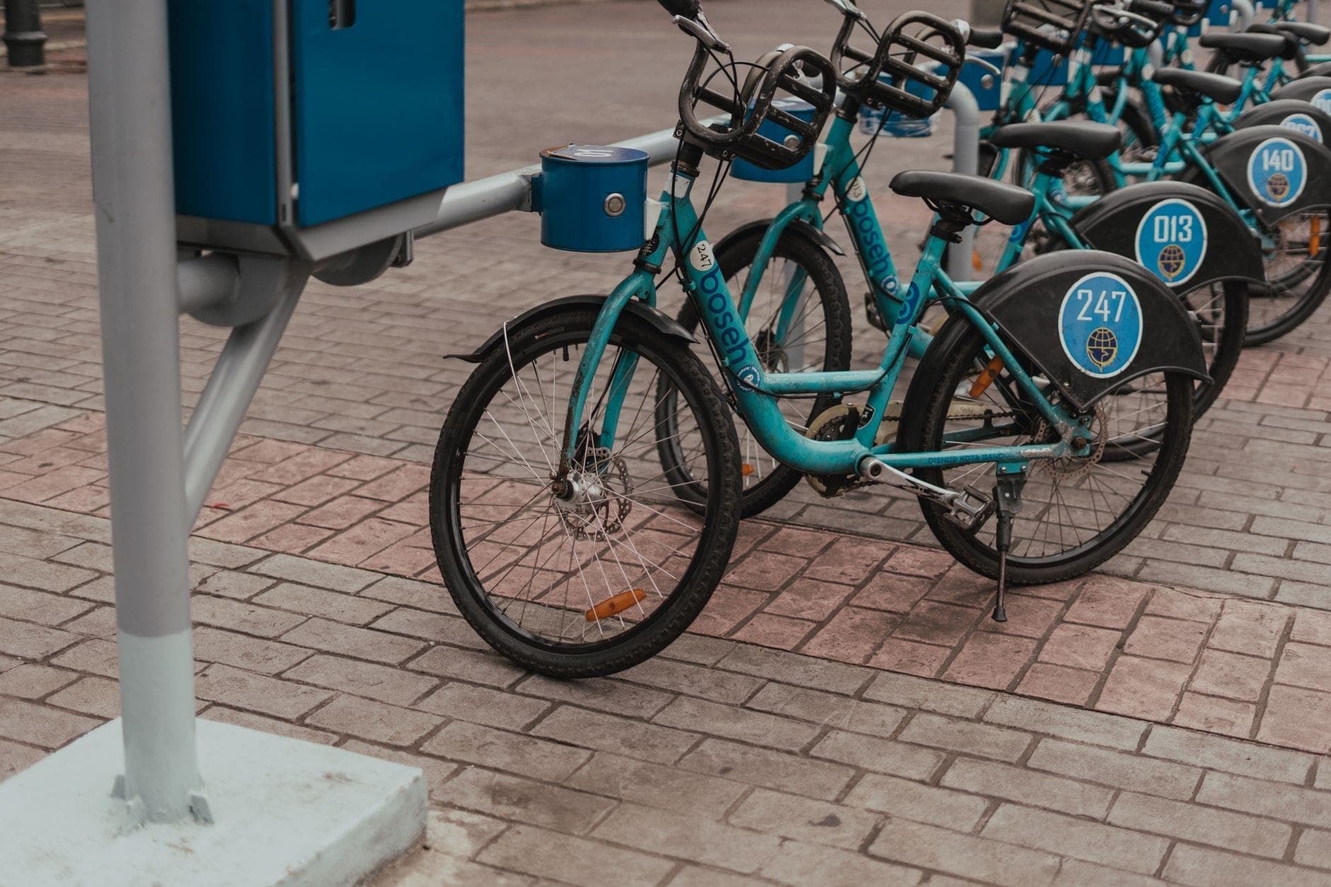 แถวจักรยานสาธารณะ MiBici จอดอยู่ที่สถานีในเมือง Guadalajara บนทางเท้าในเมือง แสดงให้เห็นจักรยานสีน้ำเงินพร้อมหมายเลขประจำตัว