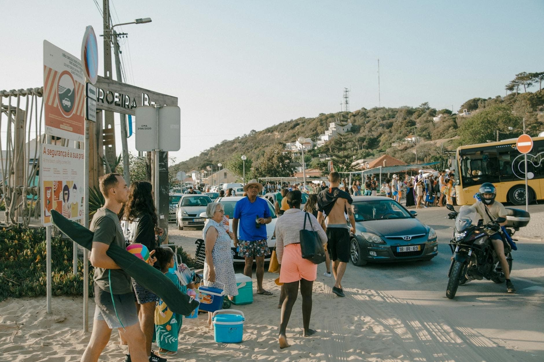 Multitudes de personas con equipo de playa y mucho tráfico cerca de un concurrido acceso a la playa de Cerdeña en verano.