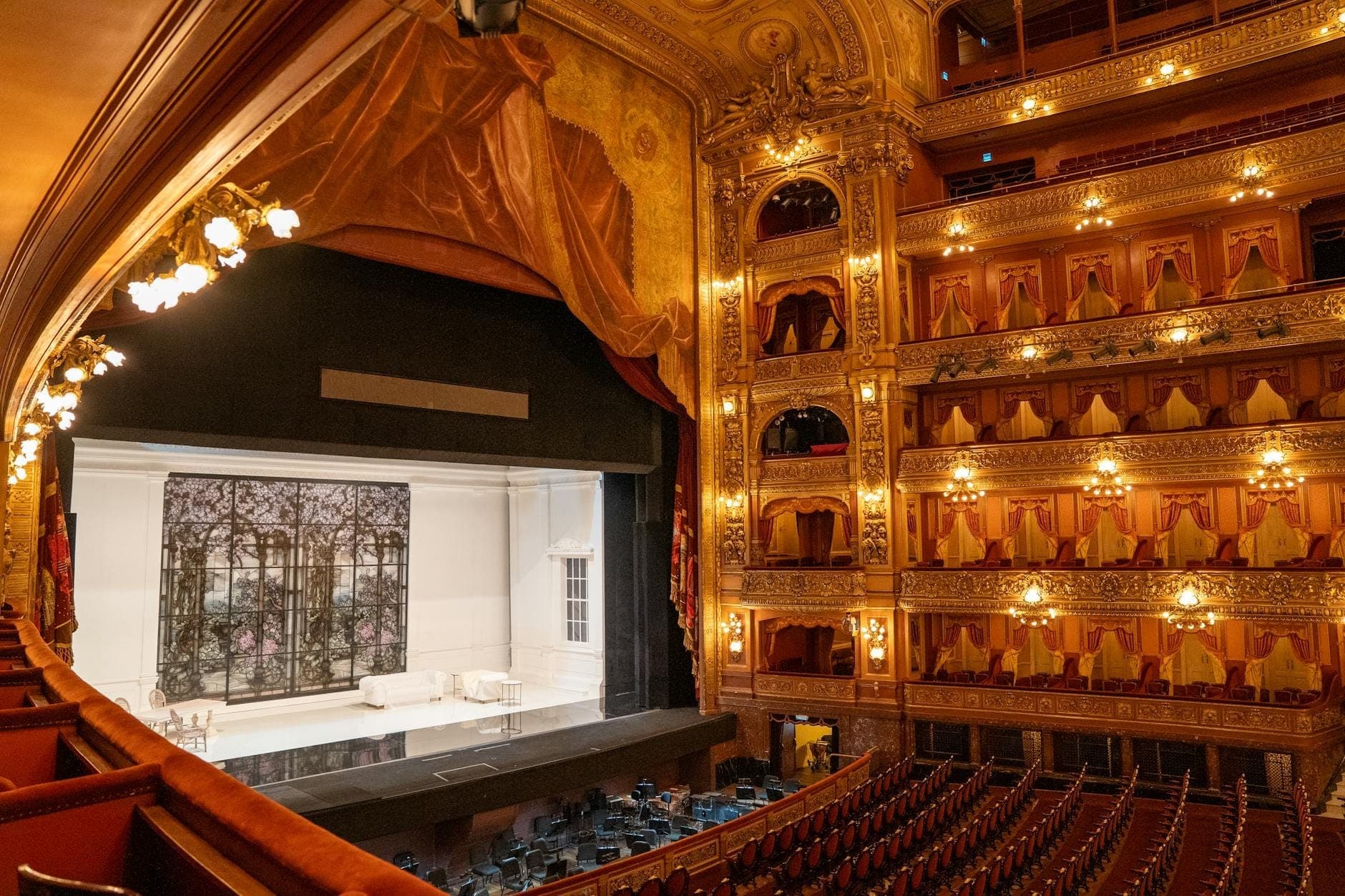 ภายในของ Gran Teatre del Liceu ที่แสดงให้เห็นระเบียงสีทองอลังการ ที่นั่งกำมะหยี่สีแดง และเวทีว่างเปล่าที่จัดเตรียมไว้สำหรับการแสดง