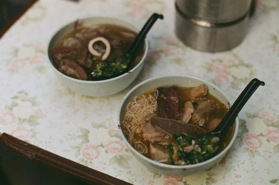 Bowls of street-style noodle soup with meat and fresh herbs in Hong Kong