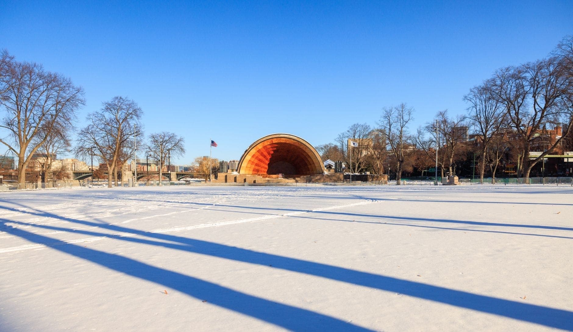 Vue large du Hatch Memorial Shell par une froide journée d'hiver ensoleillée, la neige recouvrant le sol et un ciel bleu au-dessus.
