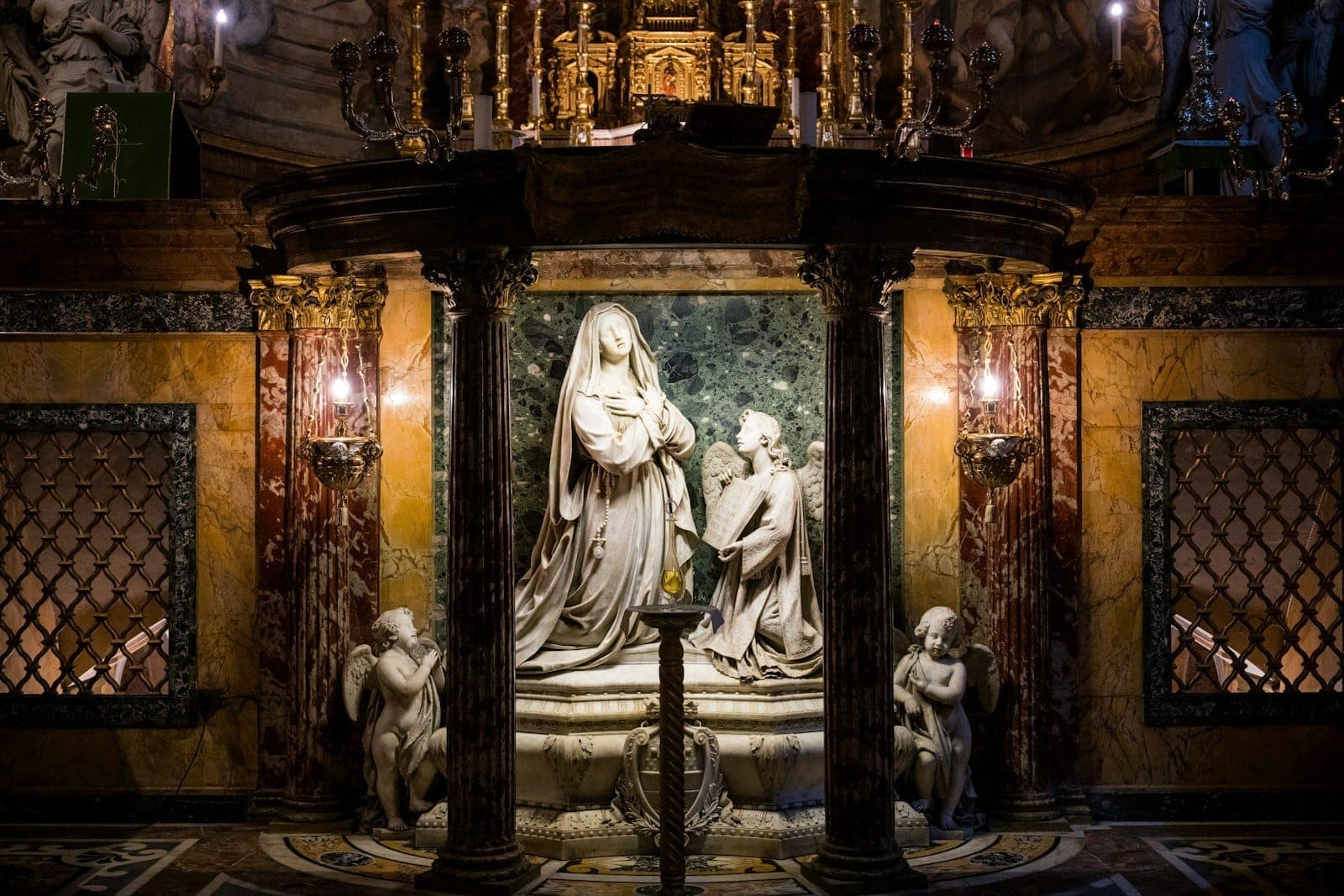 Altar marmer dengan patung-patung detail dan dekorasi emas di interior gereja Roma yang dihias dengan mewah.