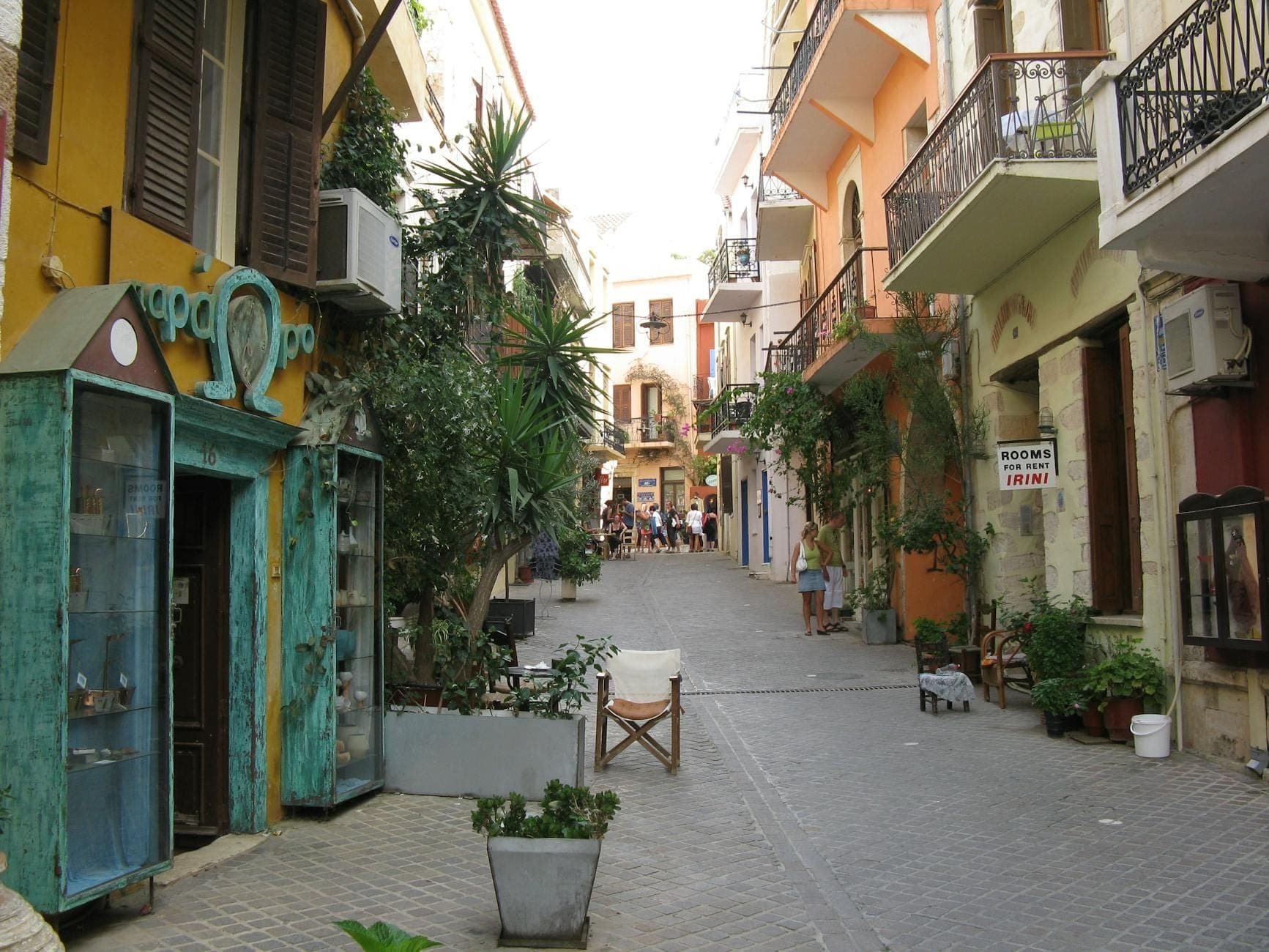 Encantadora calle del casco antiguo de Creta con coloridos edificios, plantas en macetas, pequeñas tiendas y estrechos caminos peatonales perfectos para un paseo tranquilo.
