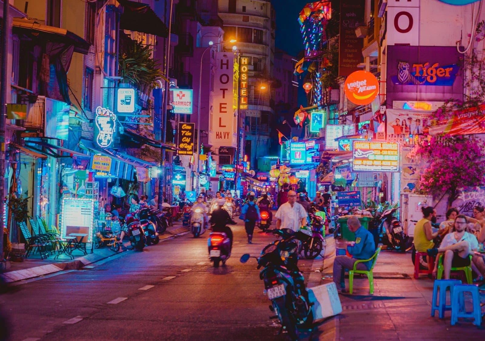 Gece neon ışıkları, barlar, sokak yemekleri ve kaldırım boyunca mavi taburelerde oturan insanlarla dolu Bùi Viện sokağı.