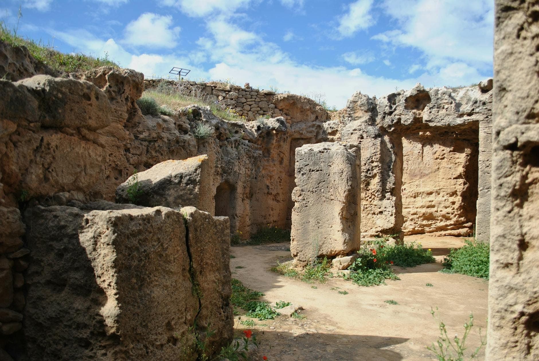 Ancient stone ruins with large upright stones and partially intact walls under a blue sky in Malta