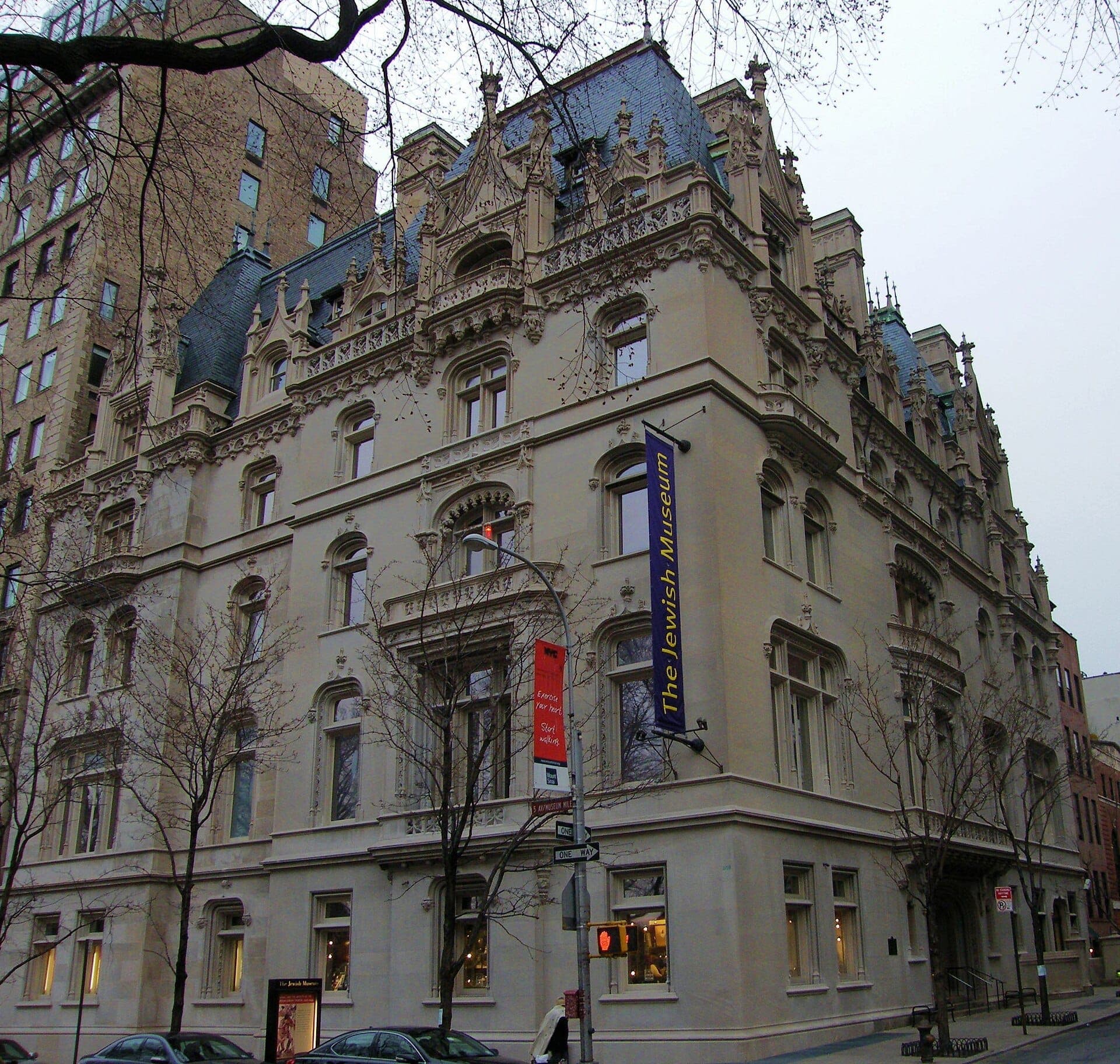 มุมมองภายนอกของ The Jewish Museum คฤหาสน์สไตล์ French Gothic บน Fifth Avenue พร้อมงานหินแกะสลักอันวิจิตรและป้ายพิพิธภัณฑ์ที่มองเห็นได้ชัดเจน