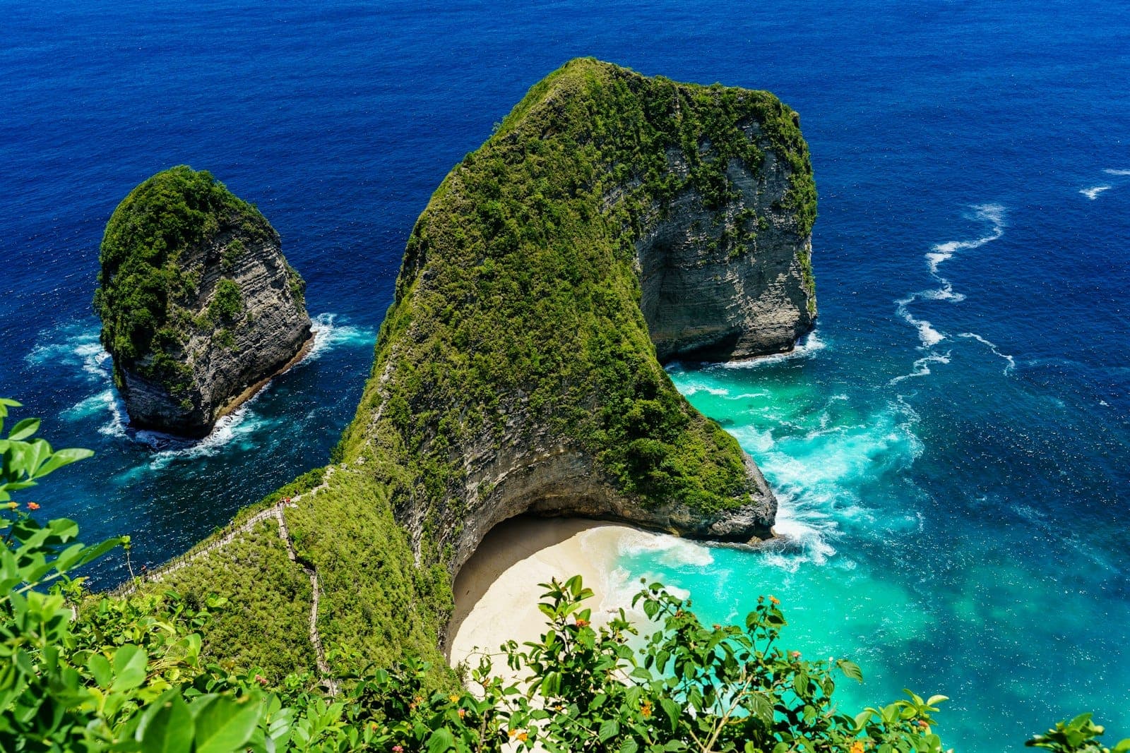 The T-Rex shaped limestone cliff at Kelingking Beach in Nusa Penida, Bali viewed from above with turquoise water below