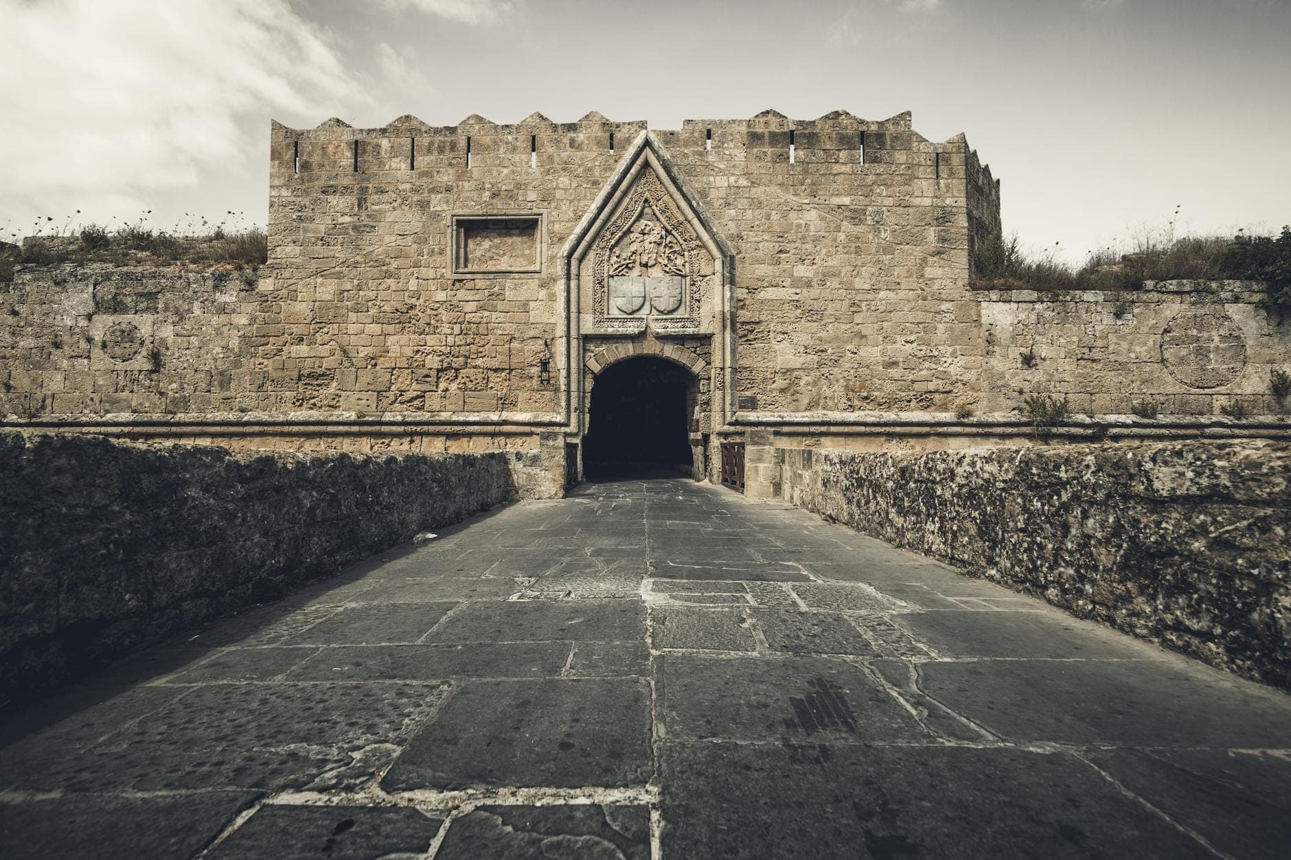 Stone medieval gate and fortified walls of Rhodes, viewed from the outside, showing the defensive entrance used during the Ottoman sieges.