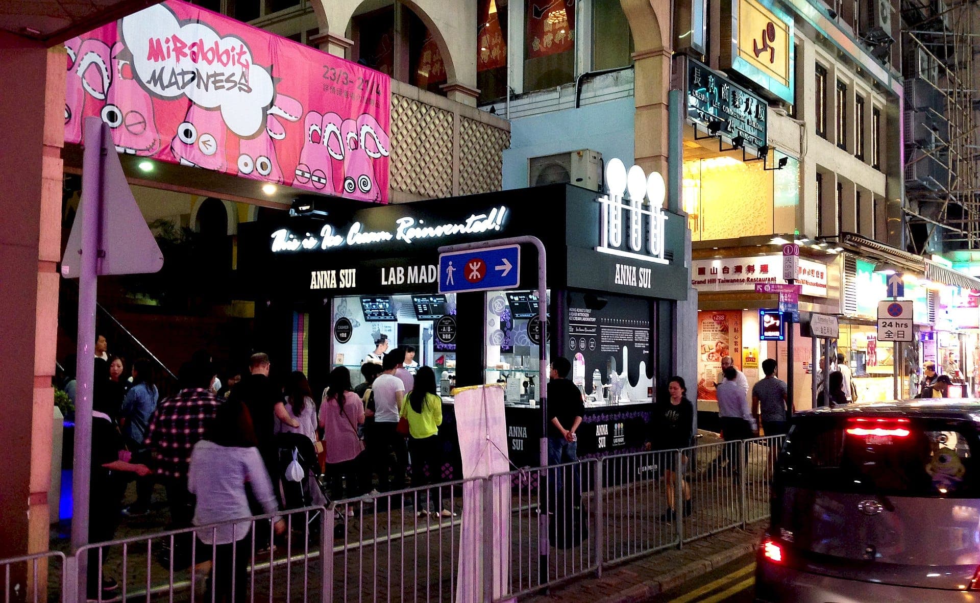 Vibrant Knutsford Terrace with colorful bars and restaurants, bustling pedestrians enjoying Kowloon nightlife near Tsim Sha Tsui.