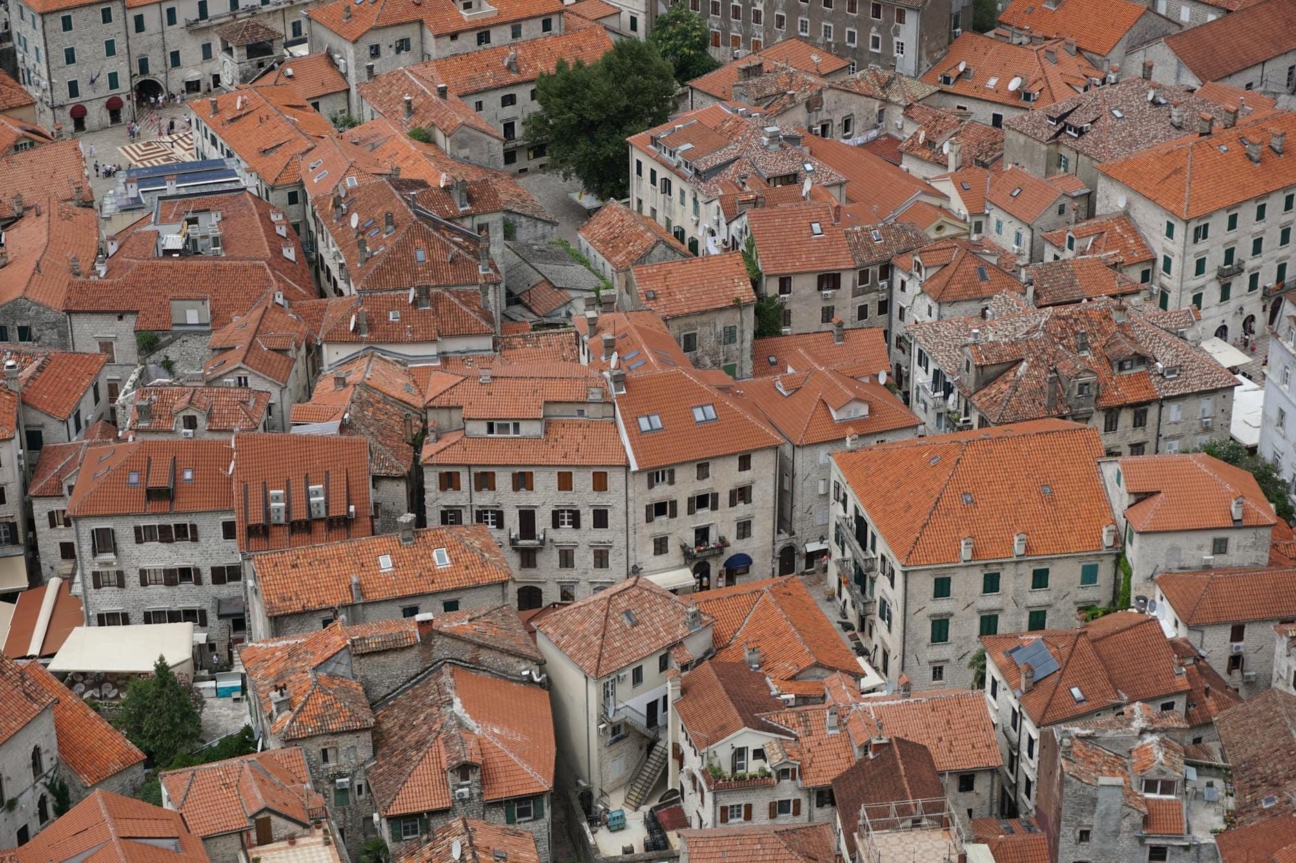 Vue aérienne de la vieille ville de Kotor avec ses toits de tuiles rouges et ses étroits bâtiments historiques, vue depuis un point en hauteur.