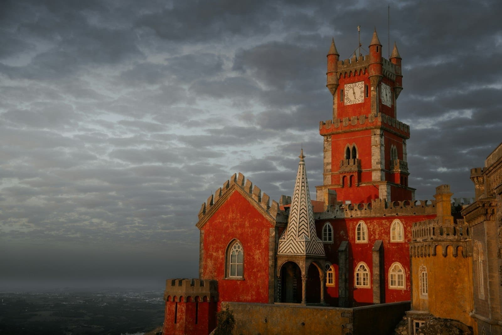 Vista sombria do Palácio da Pena em Sintra sob nuvens escuras e tempestuosas, destacando a atmosfera de inverno.