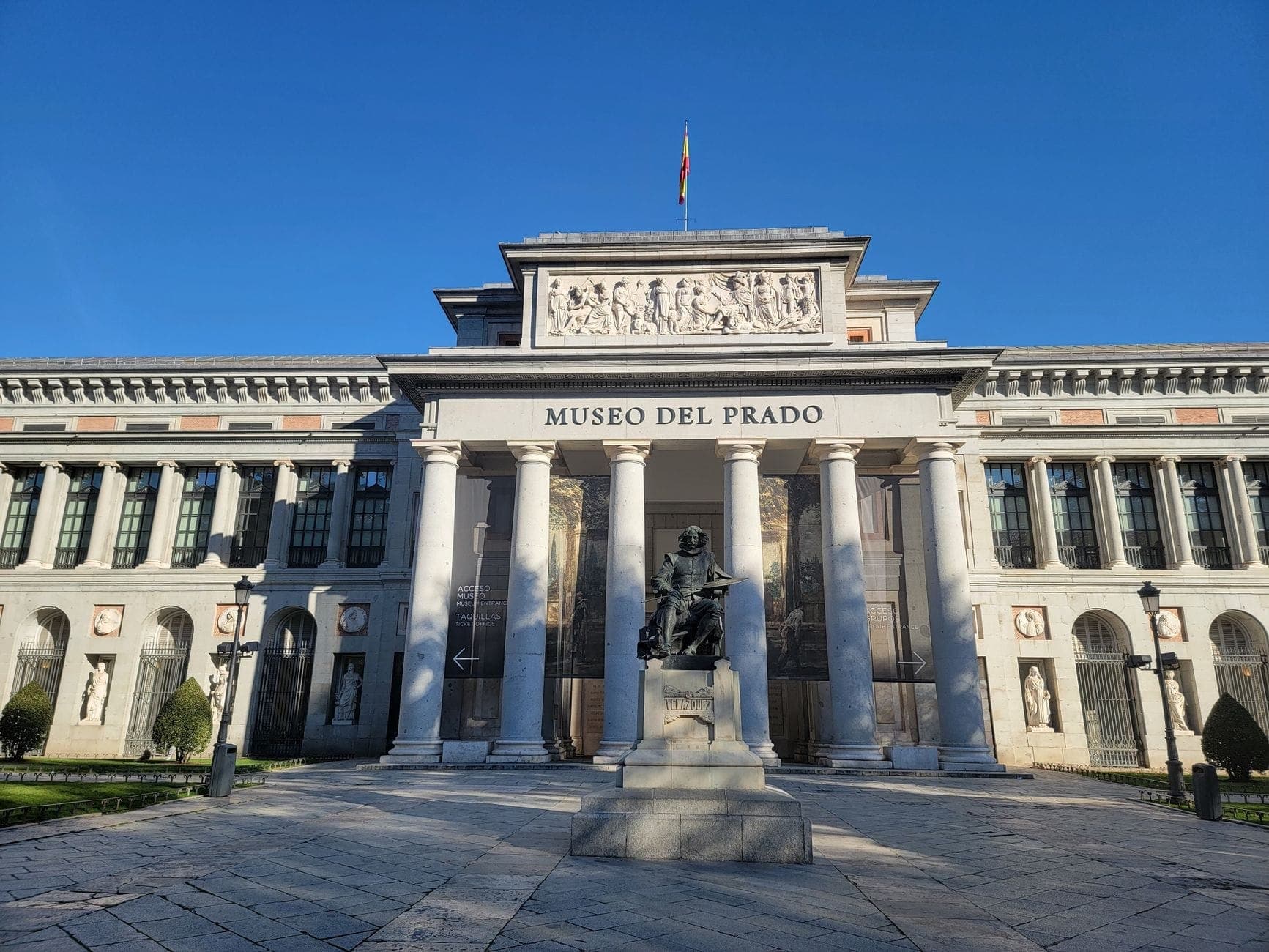 Facciata principale del Museo del Prado a Madrid con statua e cielo azzurro limpido