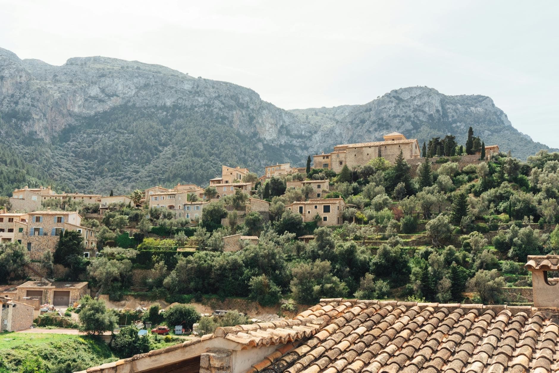 อาคารหินดั้งเดิมที่ตั้งอยู่บนเนินเขาในเทือกเขา Tramuntana ของ Mallorca ล้อมรอบด้วยต้นมะกอกและพืชพรรณแบบเมดิเตอร์เรเนียน