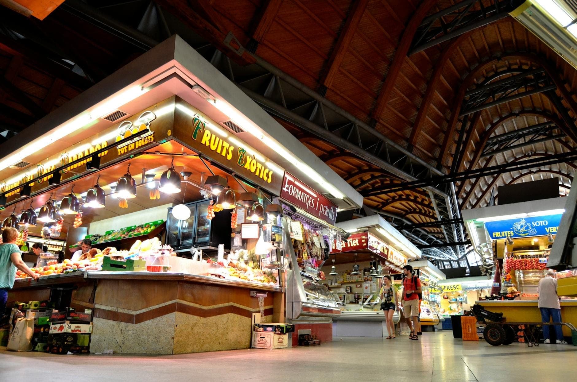 ภายในของ Mercat de Santa Caterina แสดงให้เห็นแผงขายสินค้าสดและหลังคาโมเสกโค้งลูกคลื่นอันเป็นเอกลักษณ์เหนือพื้นตลาด