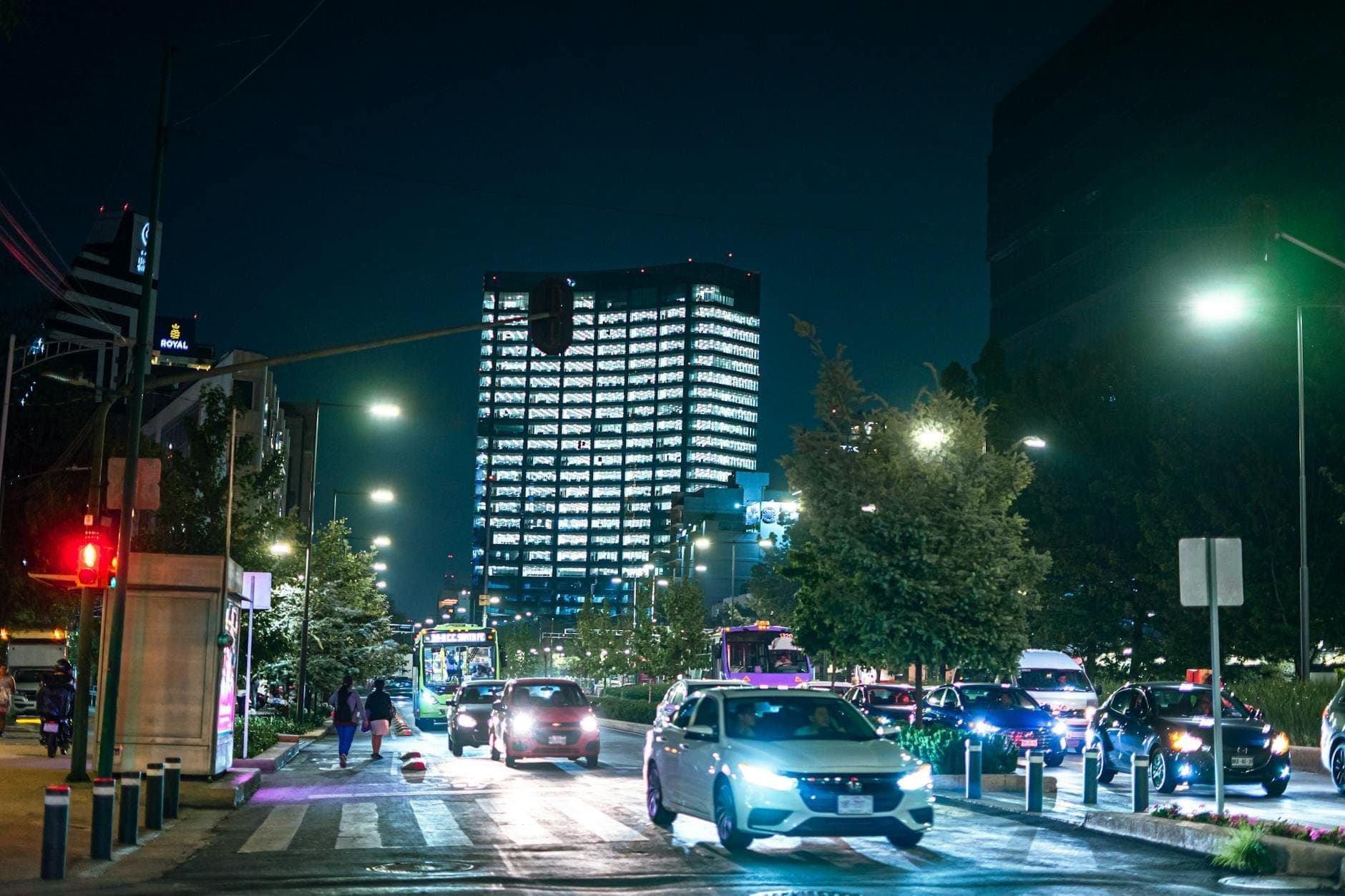 ถนนในเมือง Mexico City ยามค่ำคืน พร้อมรถยนต์ ไฟถนน และอาคารสูงทันสมัยที่สว่างไสวอยู่เบื้องหลัง