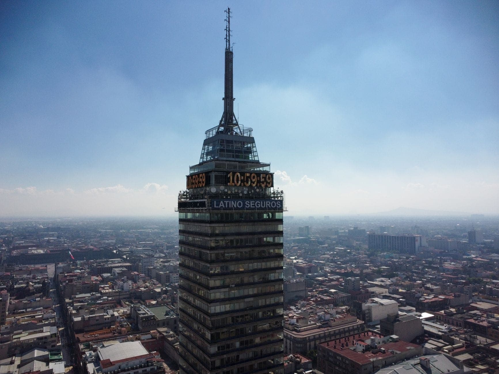 Closeup aerial view of Torre Latinoamericana observation deck, with sprawling Mexico City visible below on a clear day.