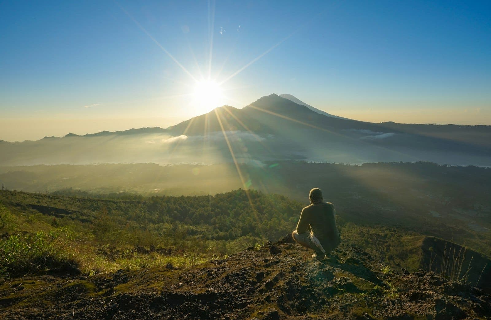 Iconic Mount Batur in Bali, showcasing panoramic sunrise vistas over Lake Batur and Mount Agung from the rugged volcanic summit.