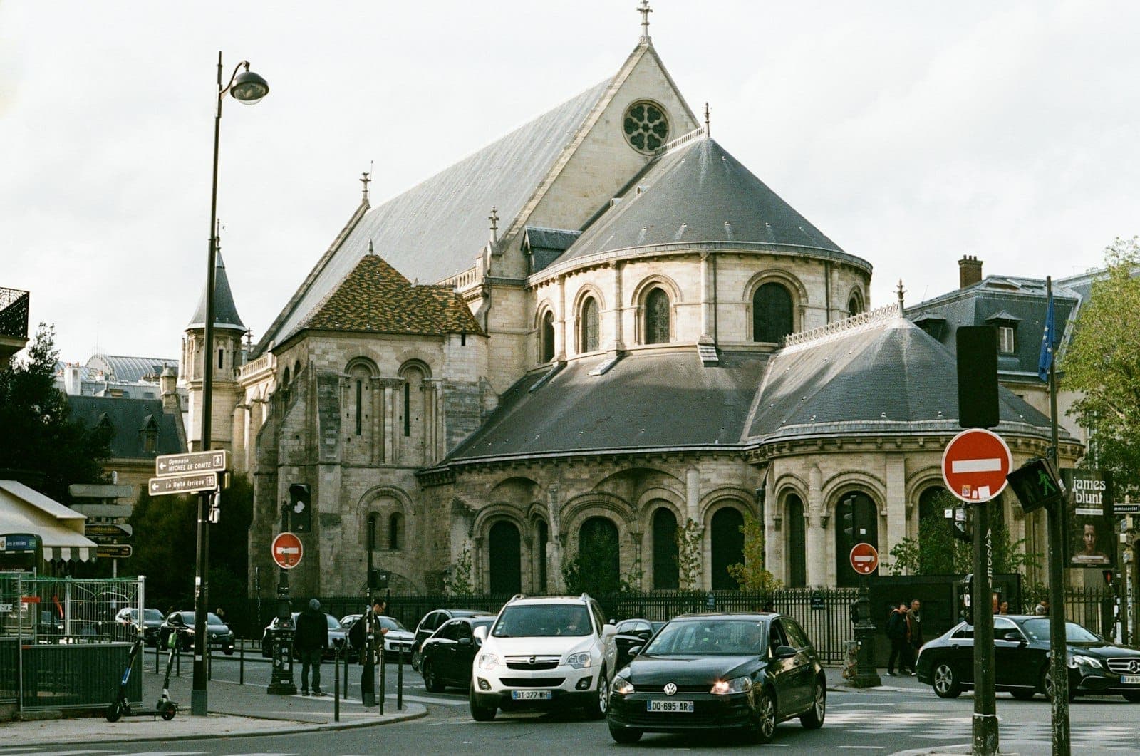 Exterior of the Musée des Arts et Métiers, a historic stone building with arched windows and a sloping gray roof seen from a Paris street.