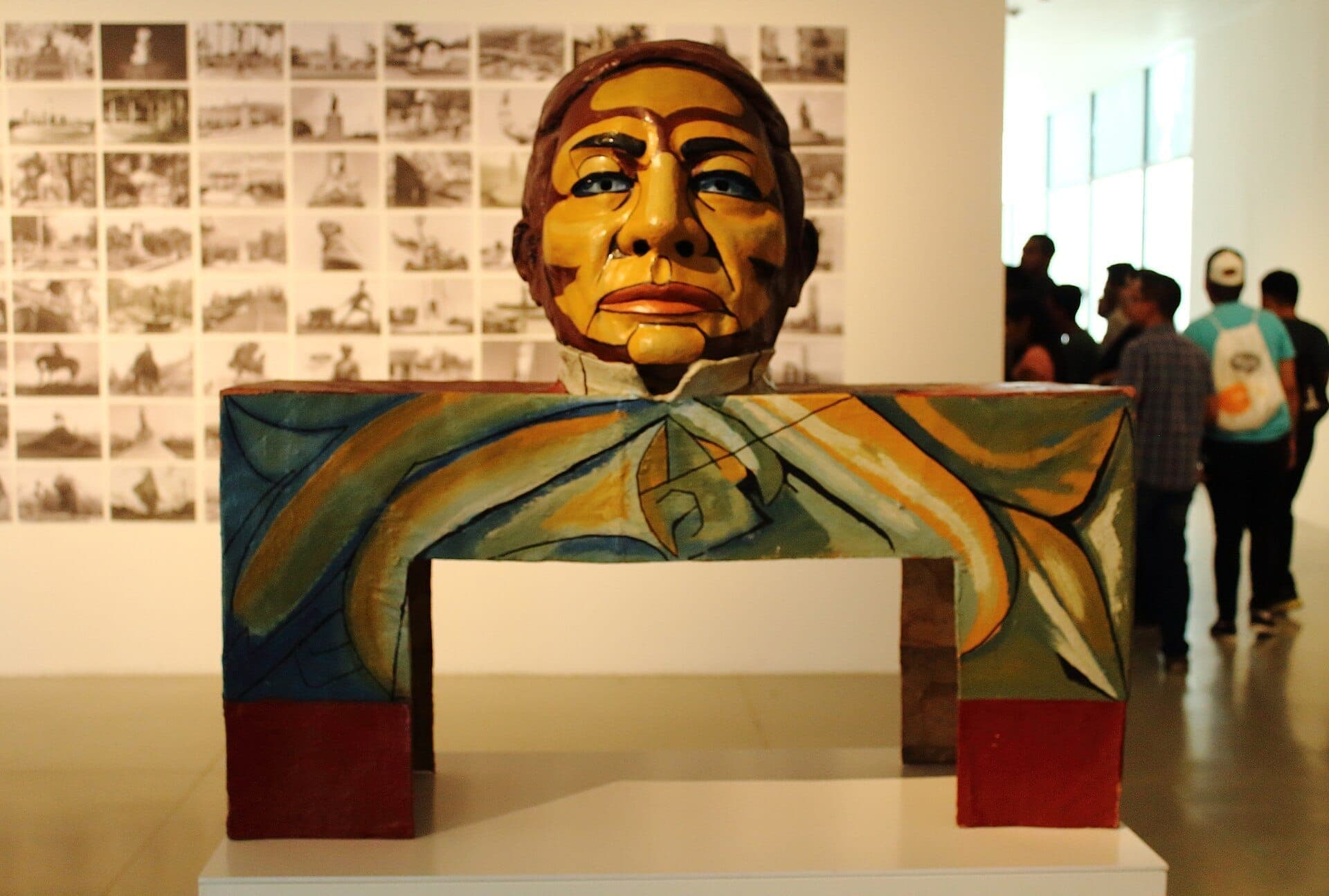 ประติมากรรมร่วมสมัยสีสันสดใสที่มีใบหน้าวาดสีจัดแสดงอยู่ที่ Museo de Arte de Zapopan โดยมีผู้เยี่ยมชมและผนังรูปภาพอยู่เบื้องหลัง