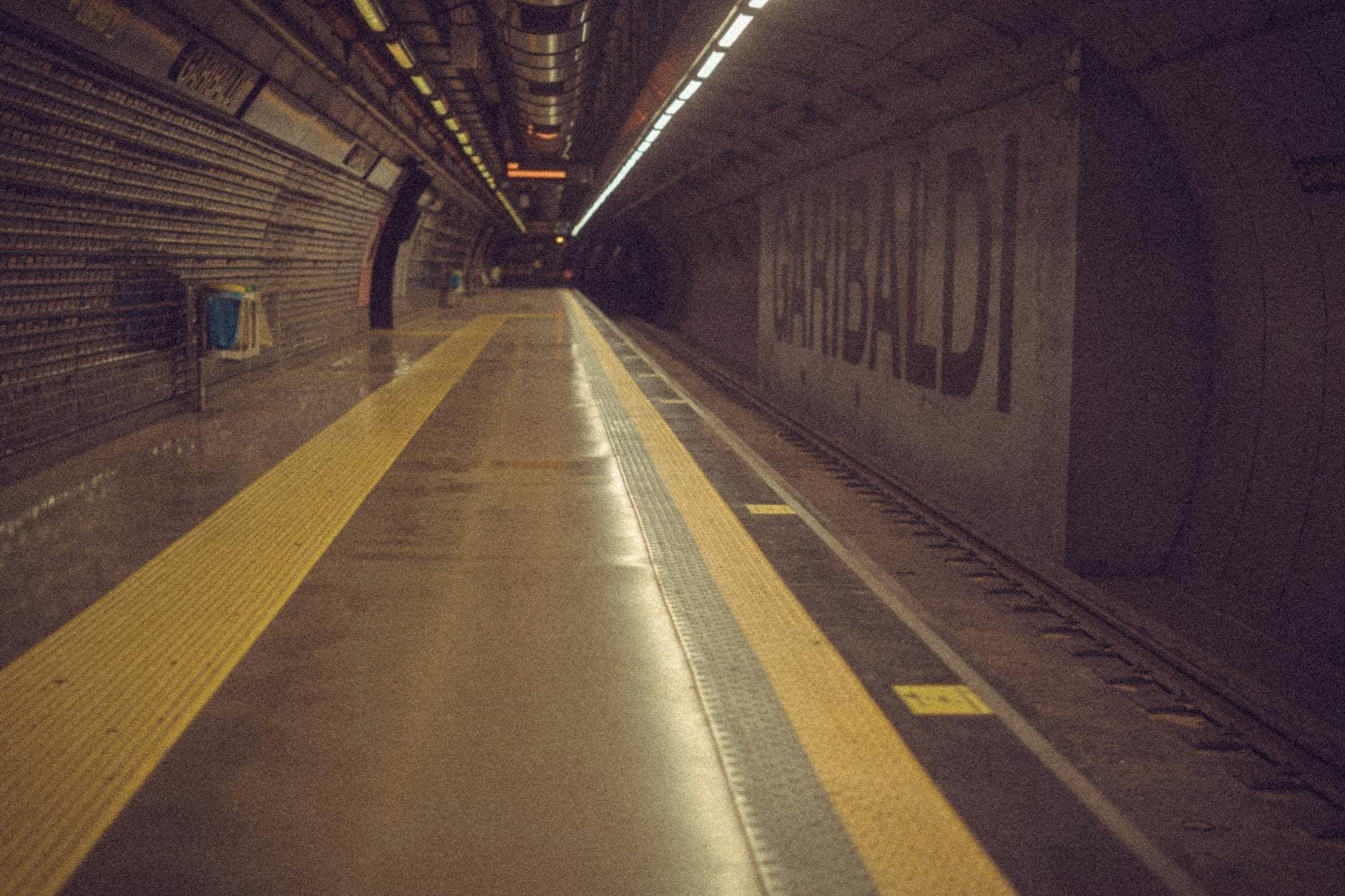 Plataforma vazia da estação de metrô Napoli Garibaldi com o nome 'Garibaldi' na parede e nenhum trem presente.