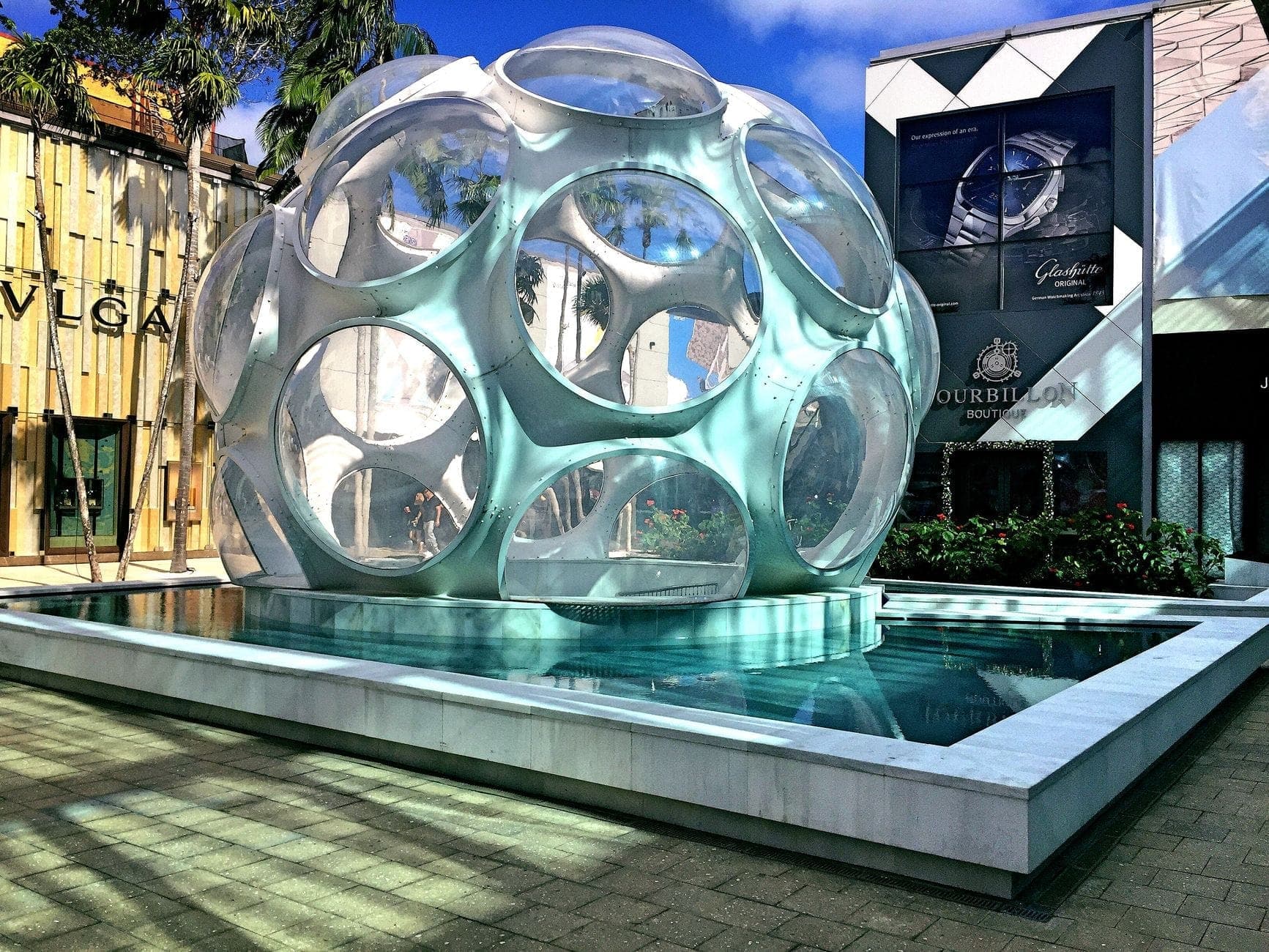 Le Palm Court du Miami Design District avec l'emblématique Fly's Eye Dome de Buckminster Fuller, entouré d'une architecture contemporaine et de boutiques de luxe.