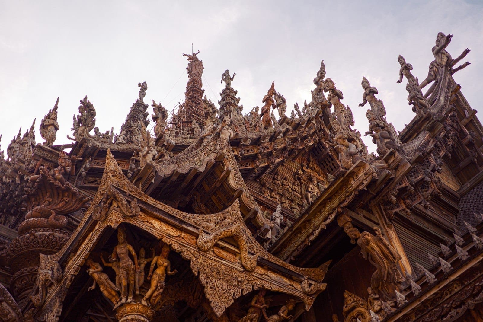 Pattaya, Tayland'daki ünlü kültürel bir simge olan Sanctuary of Truth'ta süslü ahşap oymalar ve sivri tapınak kuleleri
