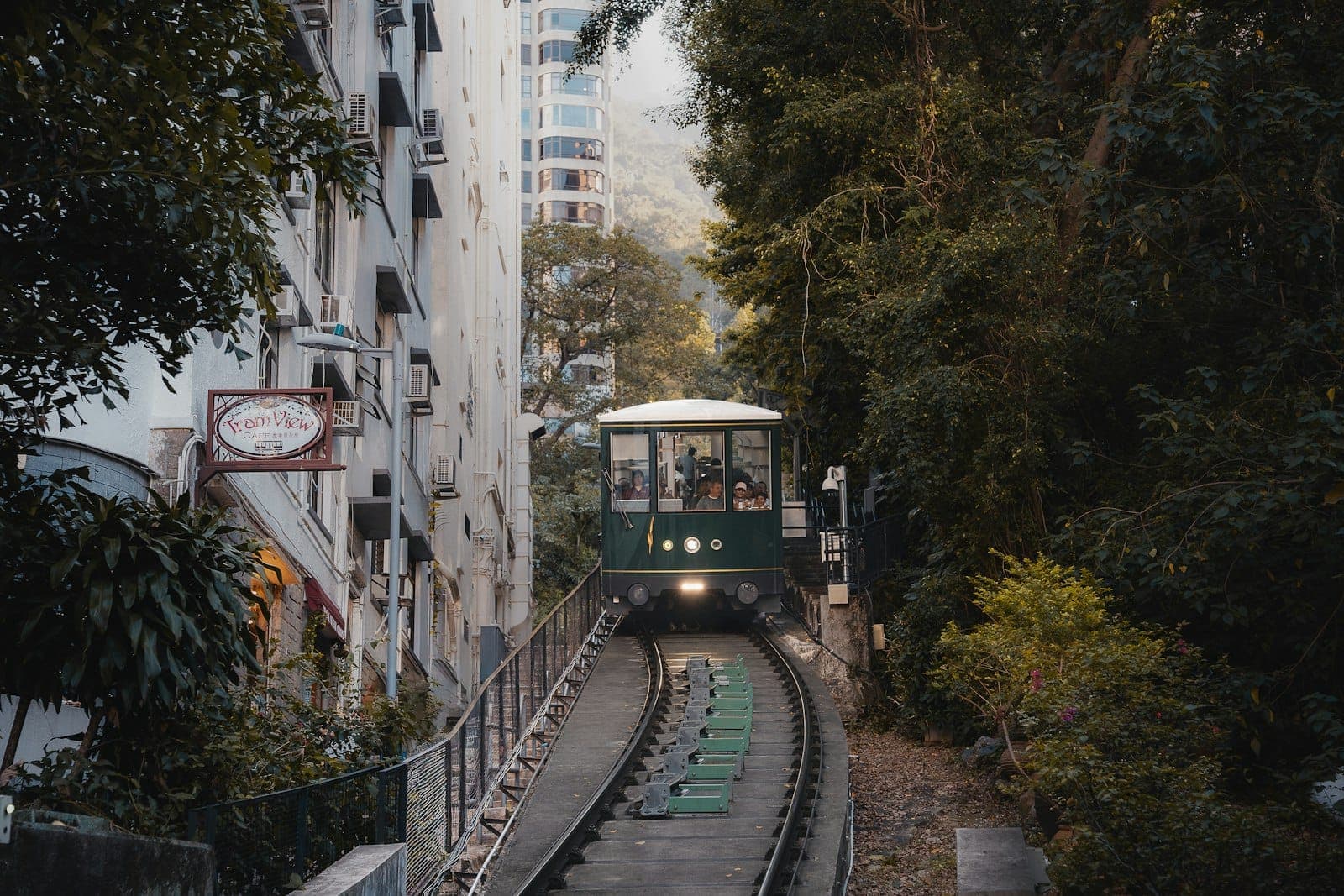 Iconic Peak Tram ascending steep tracks through lush greenery toward Victoria Peak in Hong Kong.