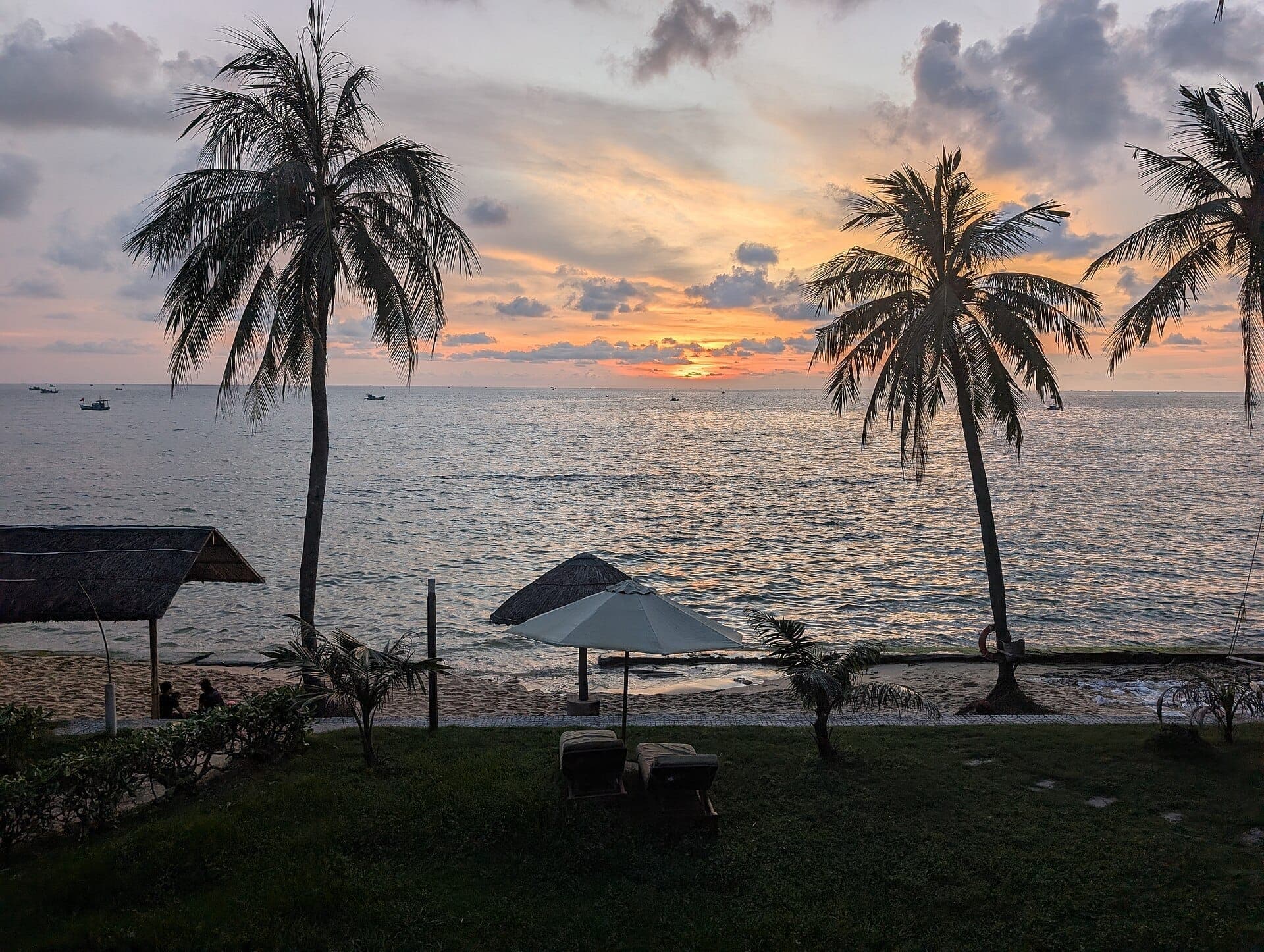 Plage de Phu Quoc au coucher du soleil avec des palmiers, une mer calme et une atmosphère détendue de resort