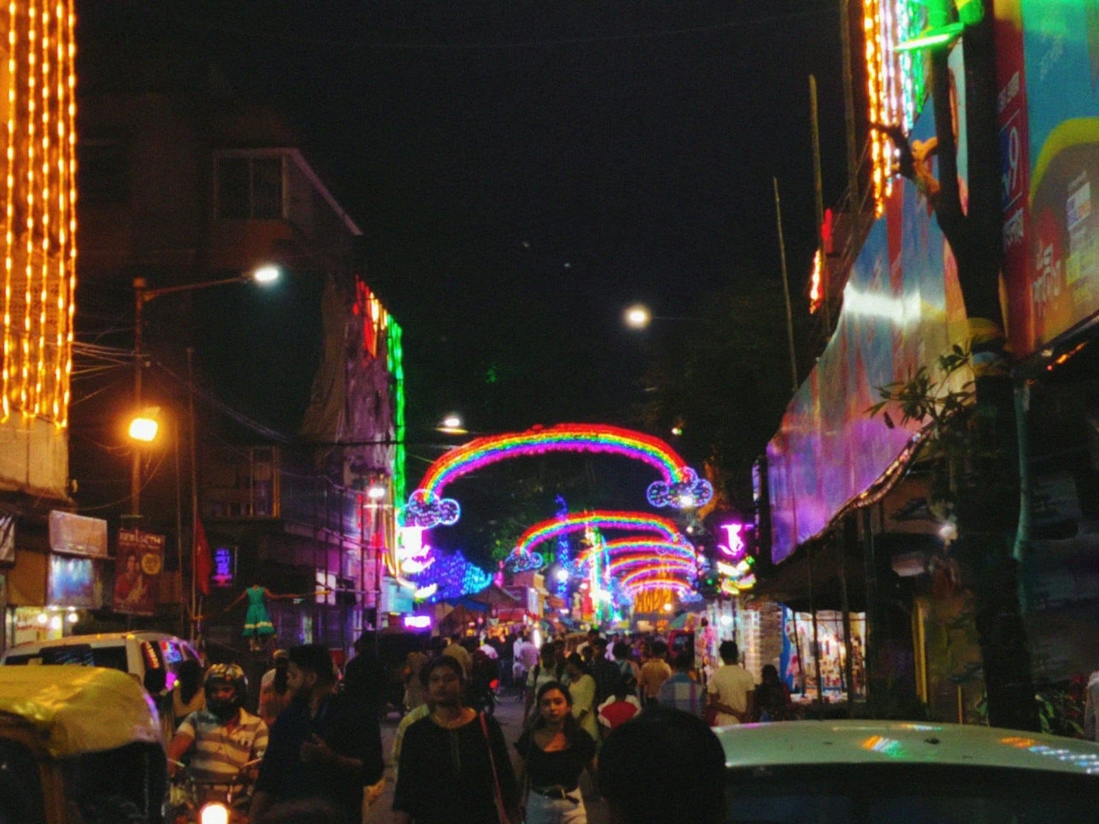 Bangla Road bondée à Patong la nuit, avec des enseignes au néon, une rue animée et des personnes marchant sous des arches colorées.