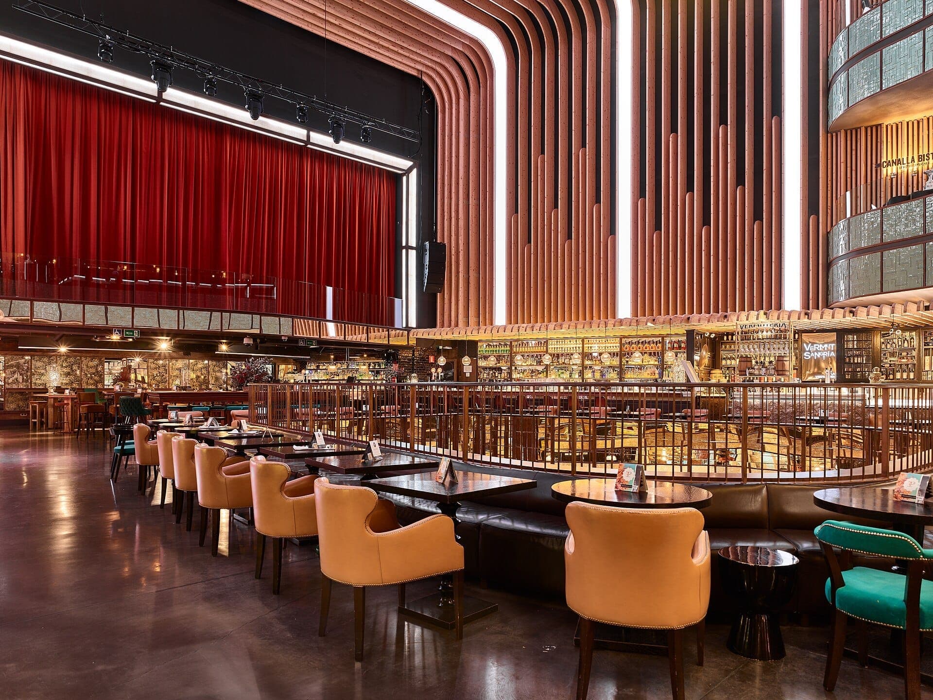 มุมมองกว้างของฮอลล์อาหาร Platea Madrid พร้อมแสงไฟสมัยใหม่ ลวดลายไม้โค้ง เก้าอี้หนัง และม่านเวทีสีแดงในโรงภาพยนตร์เก่า